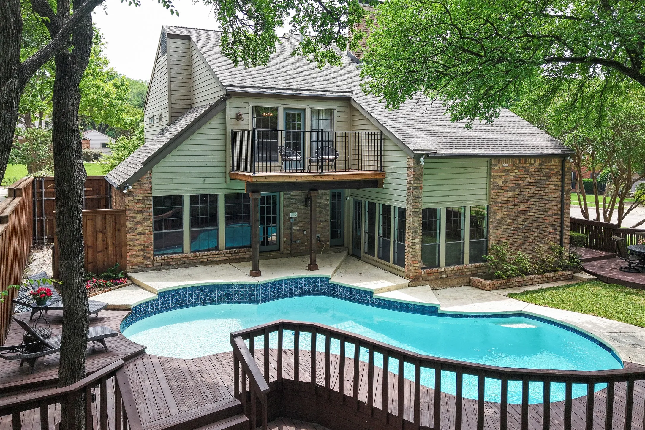 The backyard is the home’s crowning jewel—a serene oasis where a two tier deck and mature shade trees wrap the pool in privacy. Check out that upper deck off the primary bedroom!