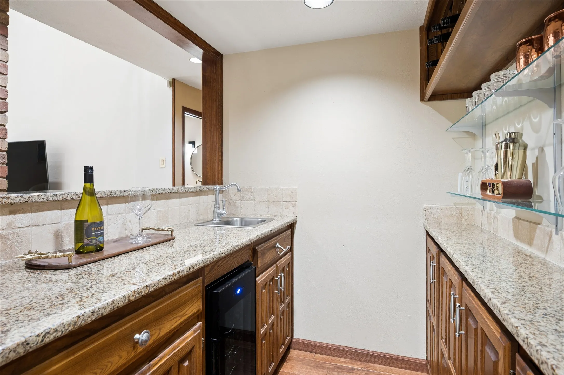Entertaining made easy with a wet bar complete with granite counters & wine-beverage fridge, positioned just off the living area.