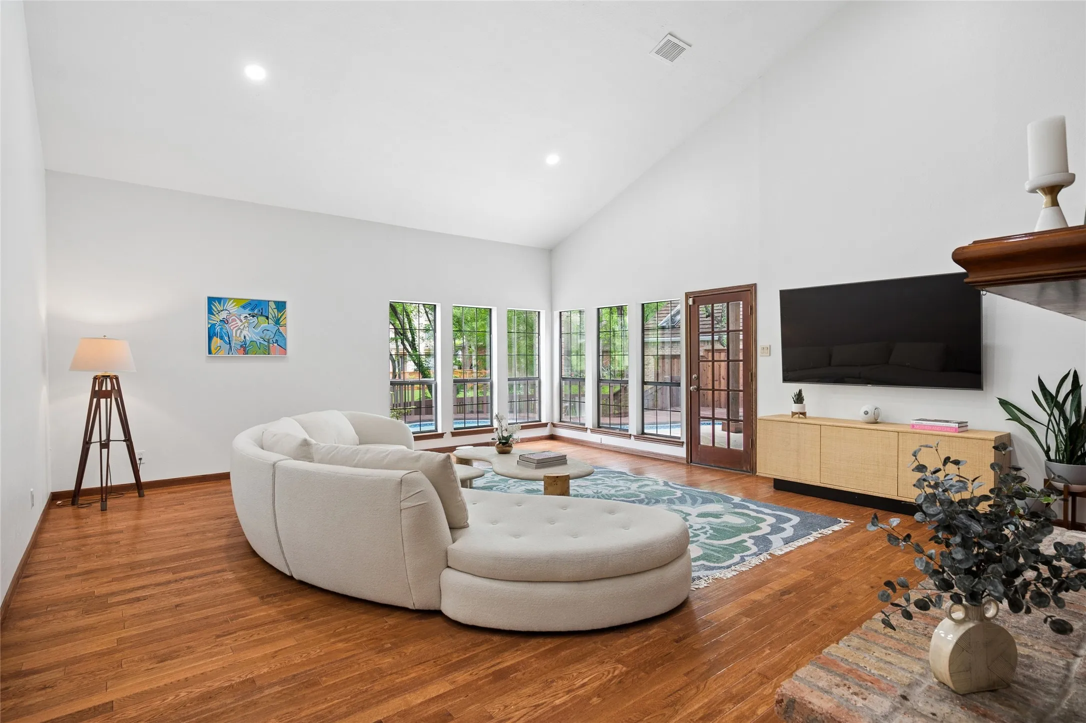 Spacious and open living area overlooks sparkling pool and scenic backyard.