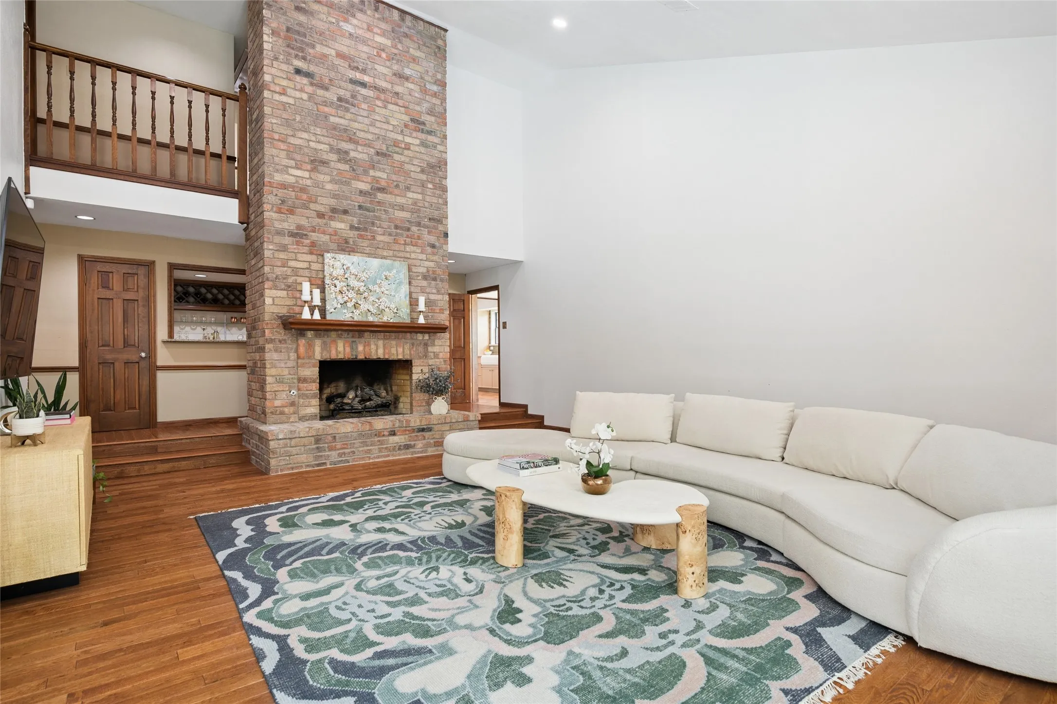 Make memories here with a stunning floor to ceiling brick fireplace that centers the living area. Rich hardwood floors everywhere with access to wet bar.