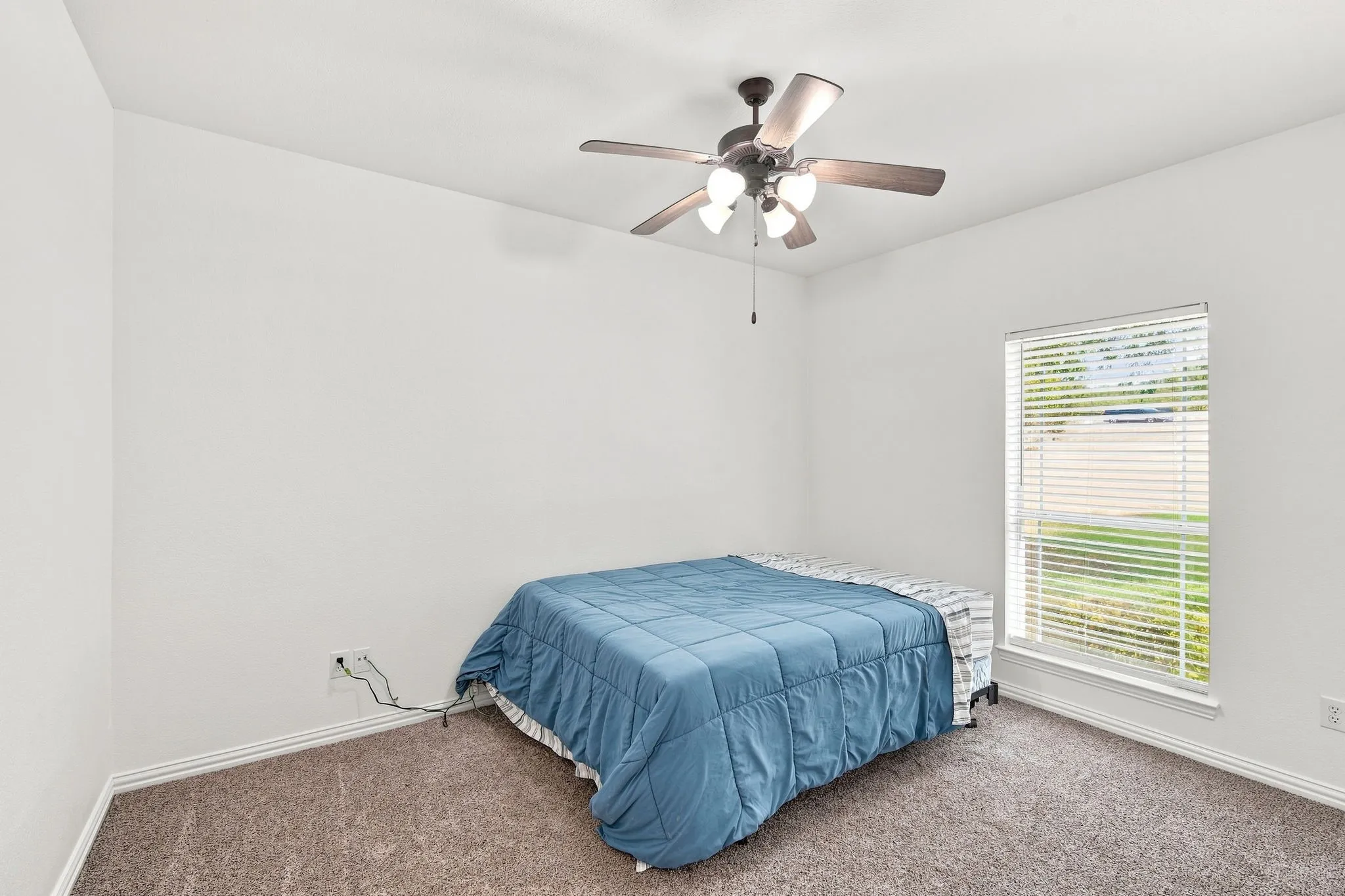 Airy bedroom featuring  neutral tones, and textured carpeting for comfort.