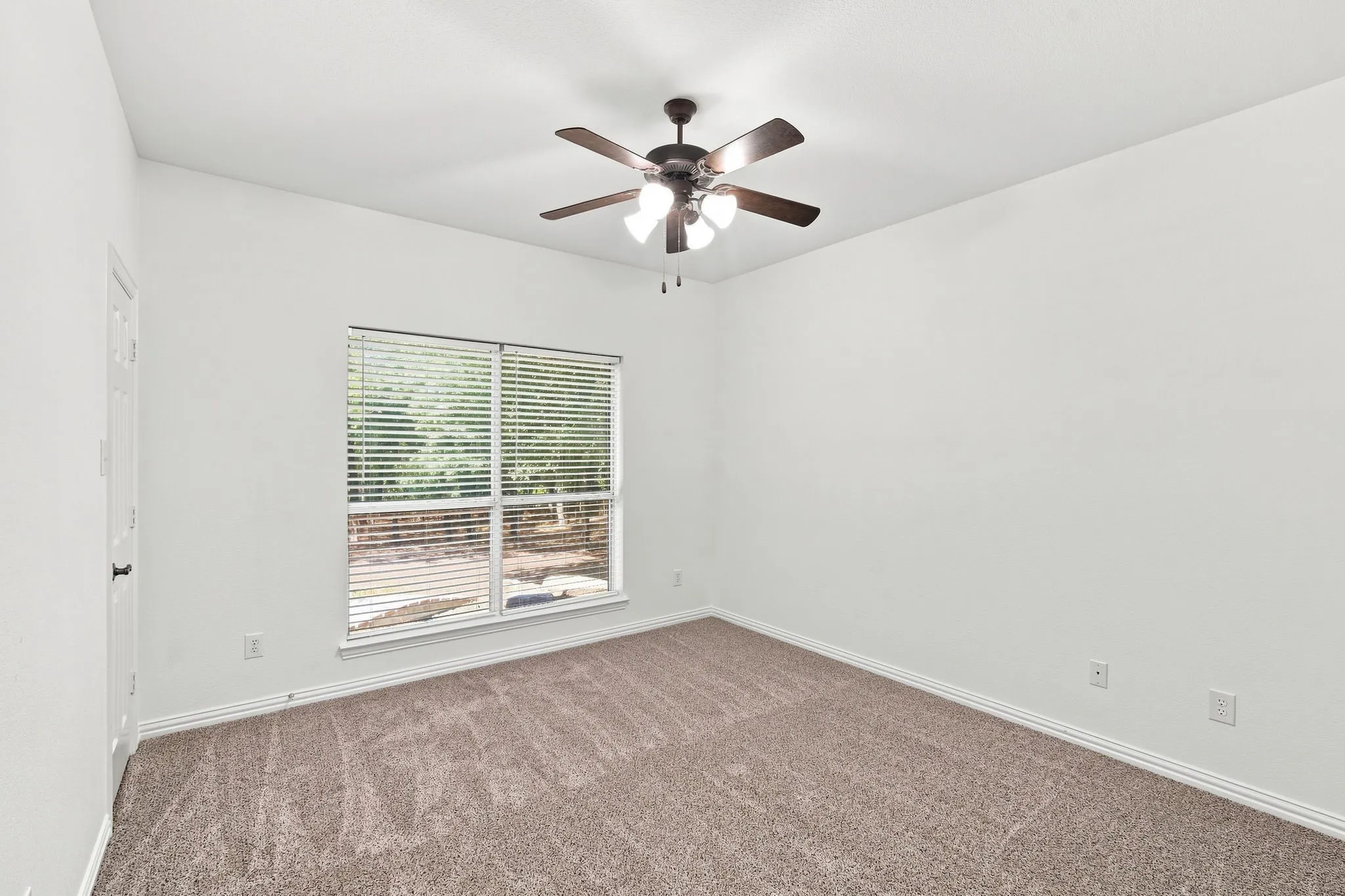 Comfortable bedroom with soft neutral carpeting and crisp white walls, ready for your personal touch.