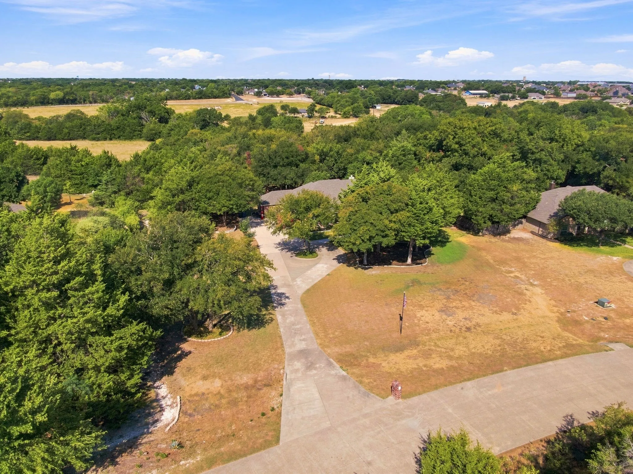 Aerial perspective highlighting the sprawling, tree-lined acreage that surrounds this private property.