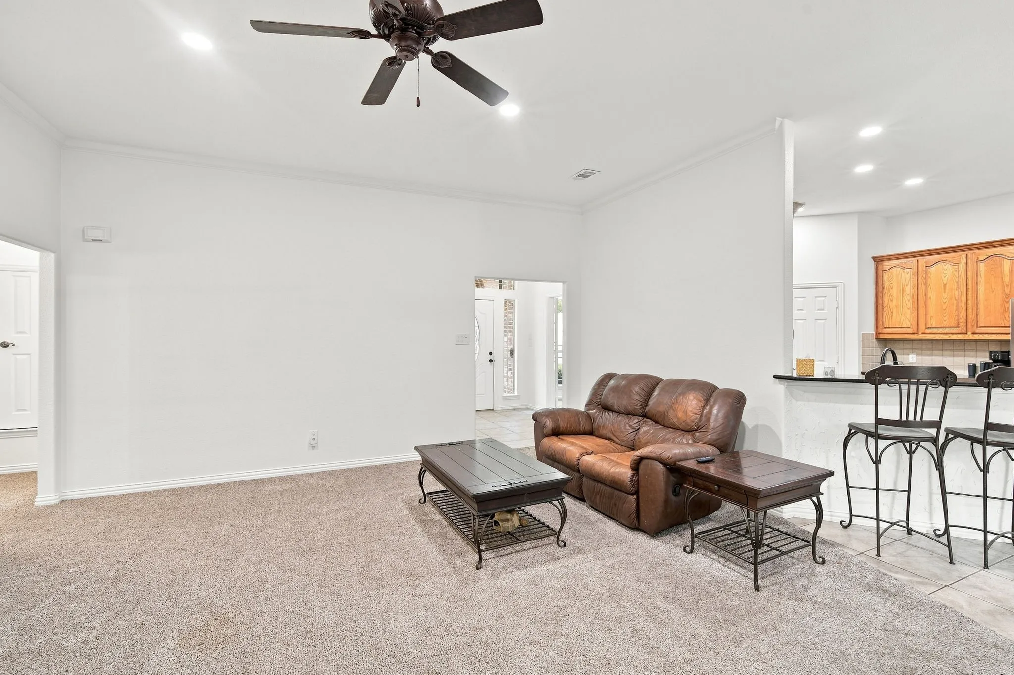 Bright, open living area with recessed lighting, a ceiling fan, and a convenient breakfast bar for casual entertaining.