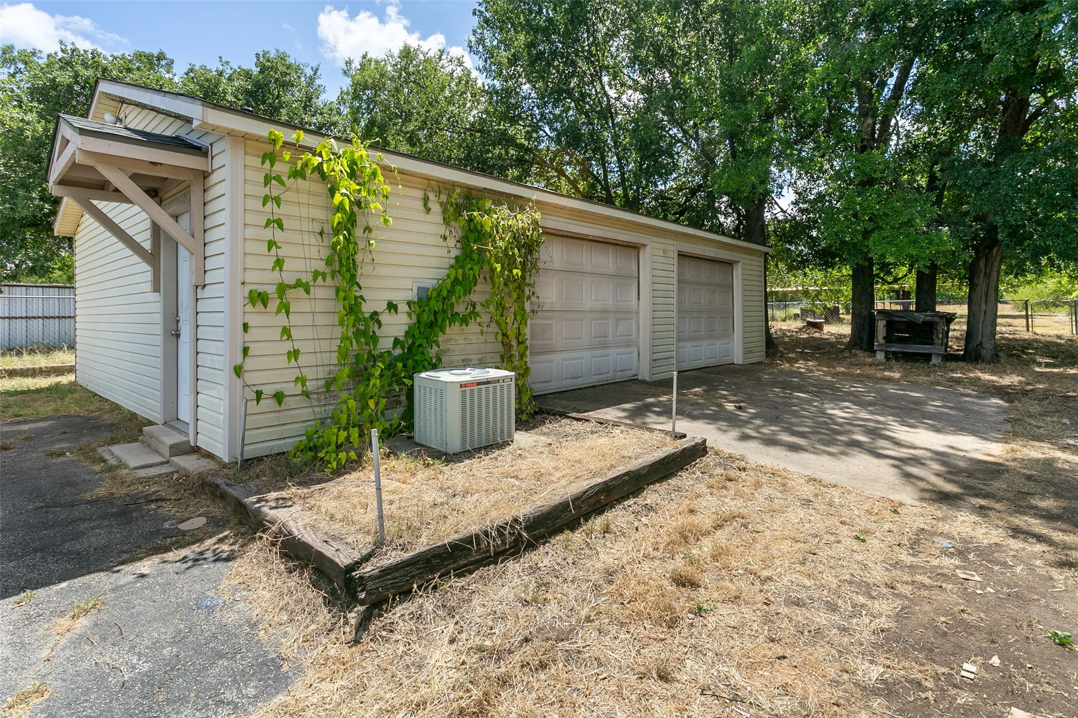 Attached two-car garage with overhead doors and an exterior entry