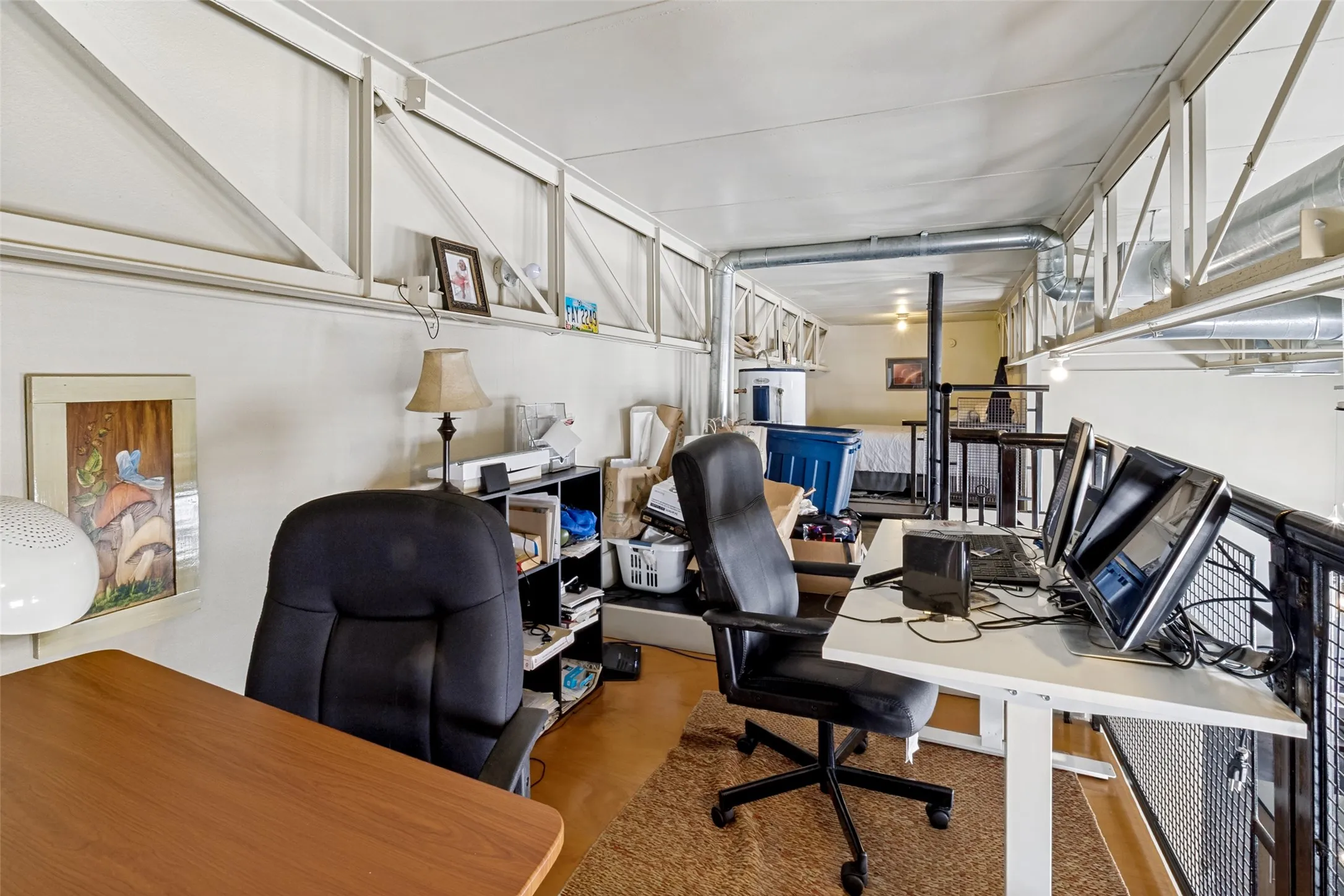 Loft space with industrial-style exposed ductwork and metal railing