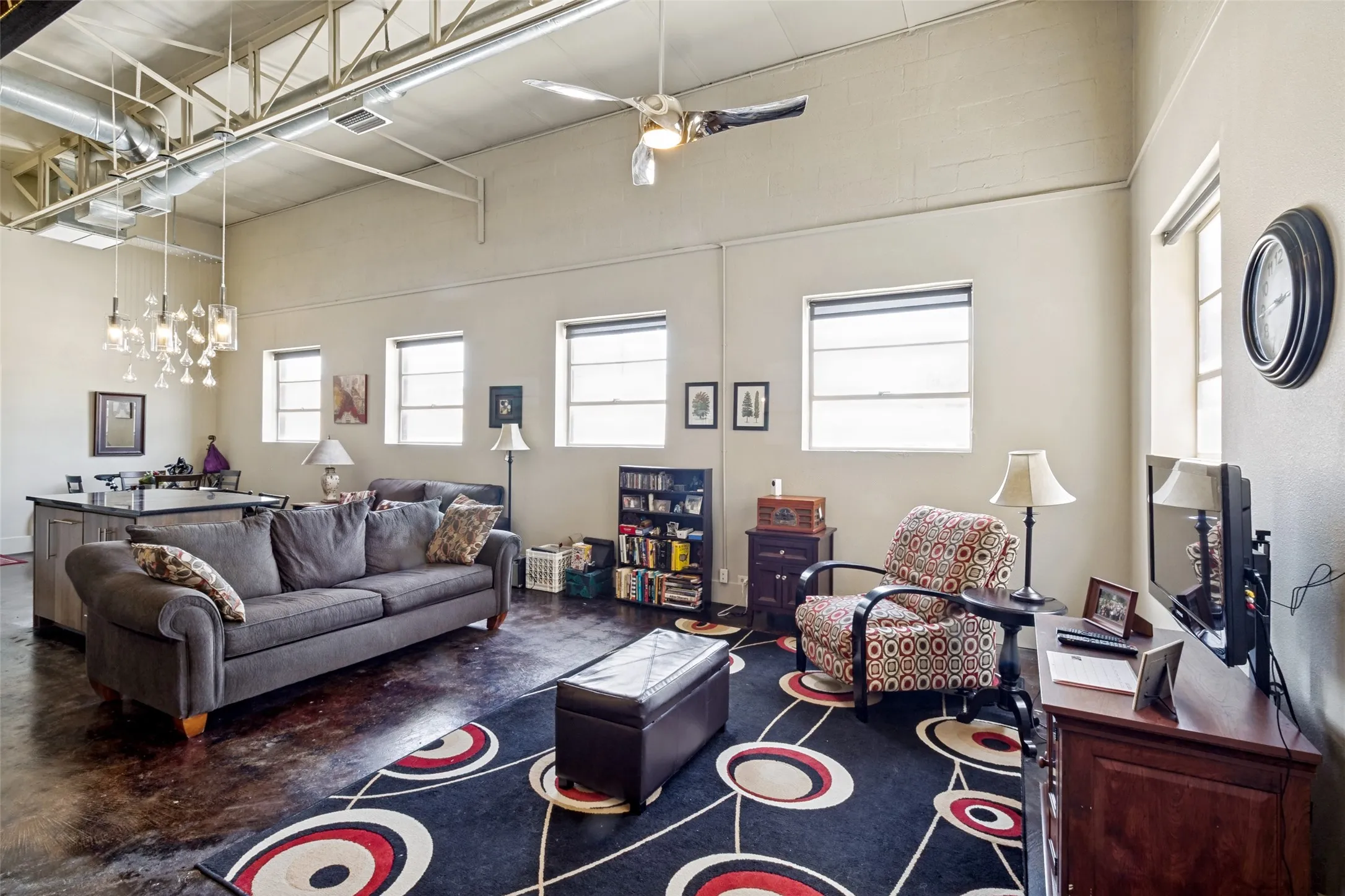 Exposed ductwork and structural beams, high ceilings, multiple with great light from the windows, concrete flooring.