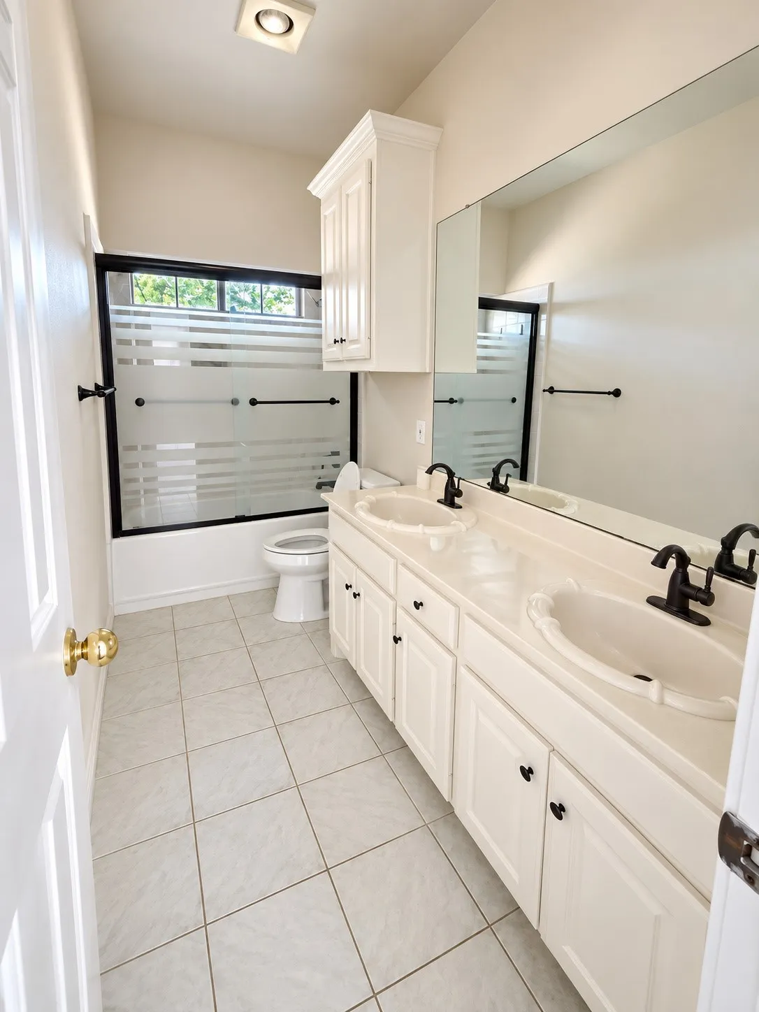 Dual vanity with integrated sinks, white cabinetry, and matte black fixtures