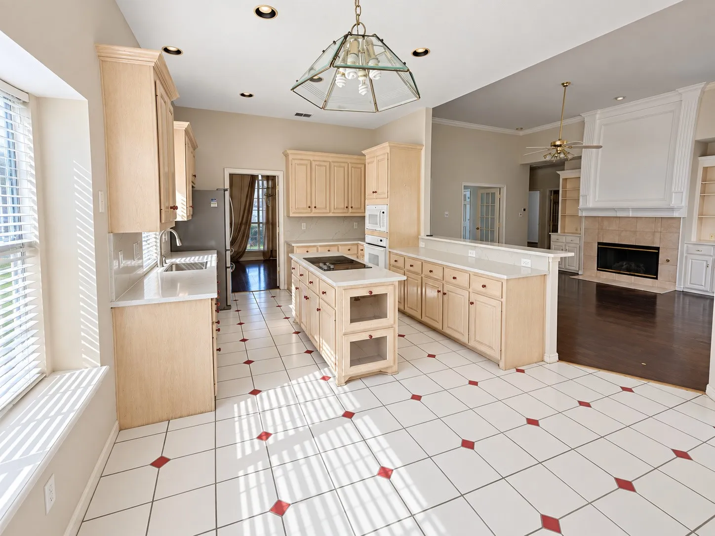 Kitchen featuring a central island, integrated stovetop, light-toned cabinetry, and white countertops