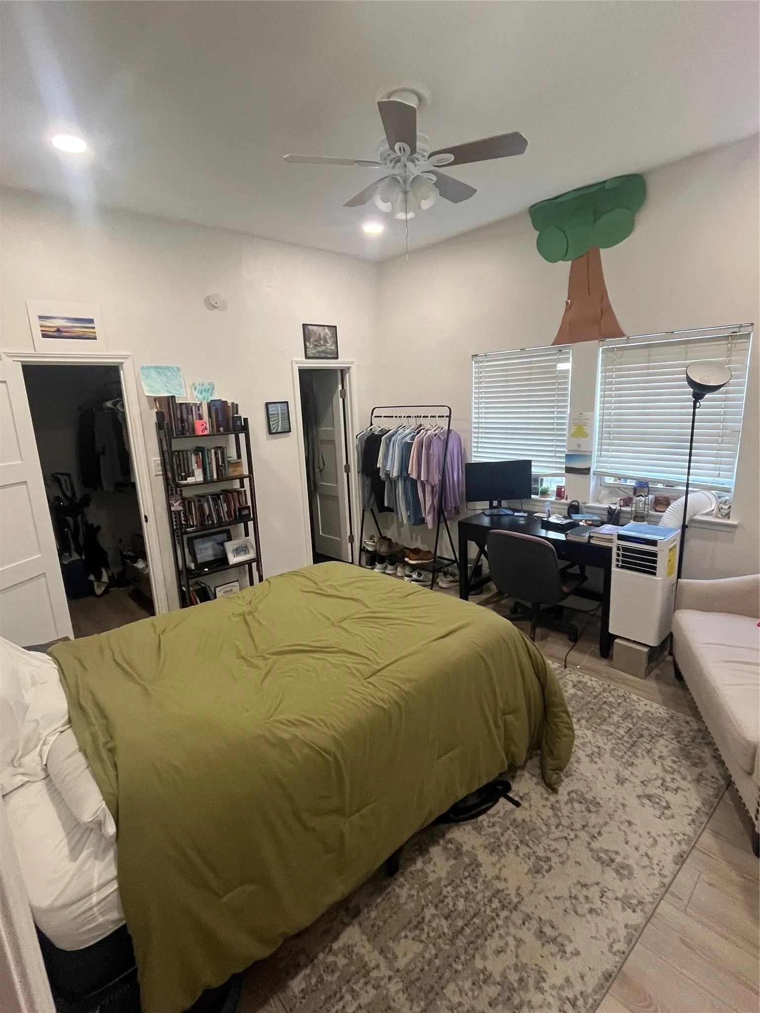 Light-filled room featuring wood-finish flooring, recessed lighting, and a ceiling fan
