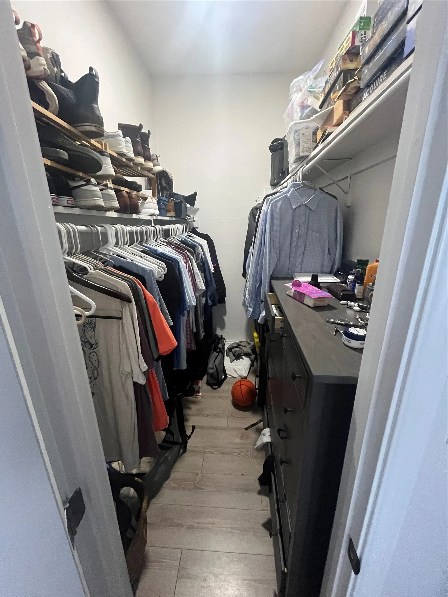 Walk-in closet featuring light wood-finish flooring and white walls