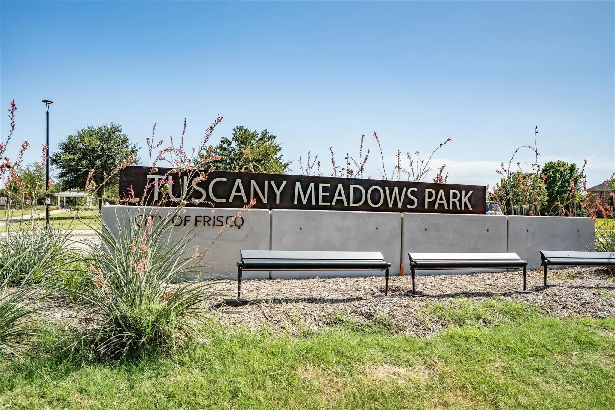 Tuscany Meadows Park signage with concrete base, metal lettering, and metal benches