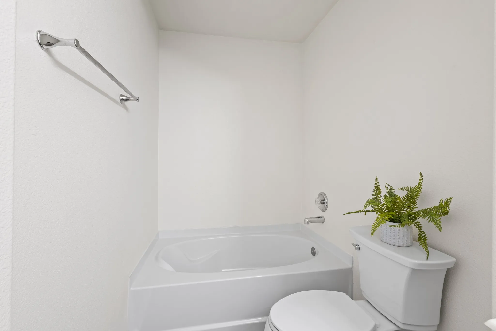 White soaking tub and toilet with chrome fixtures