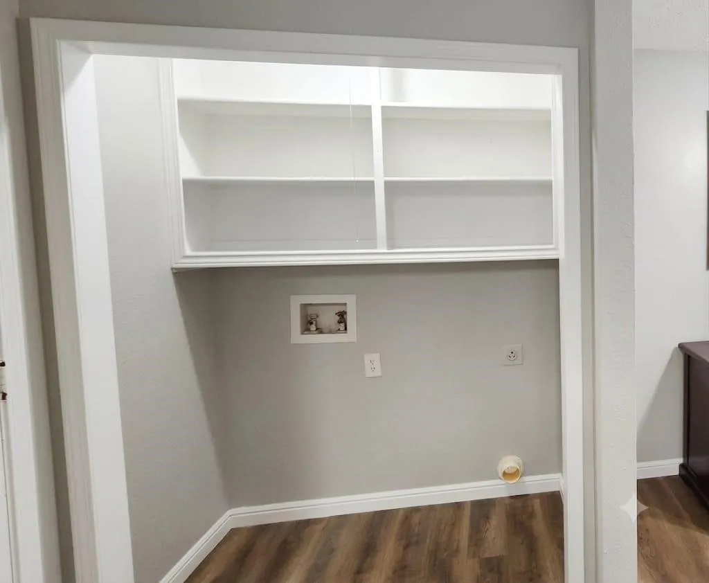 Built-in shelving, wood-finish flooring, light gray wall paint, and white trim