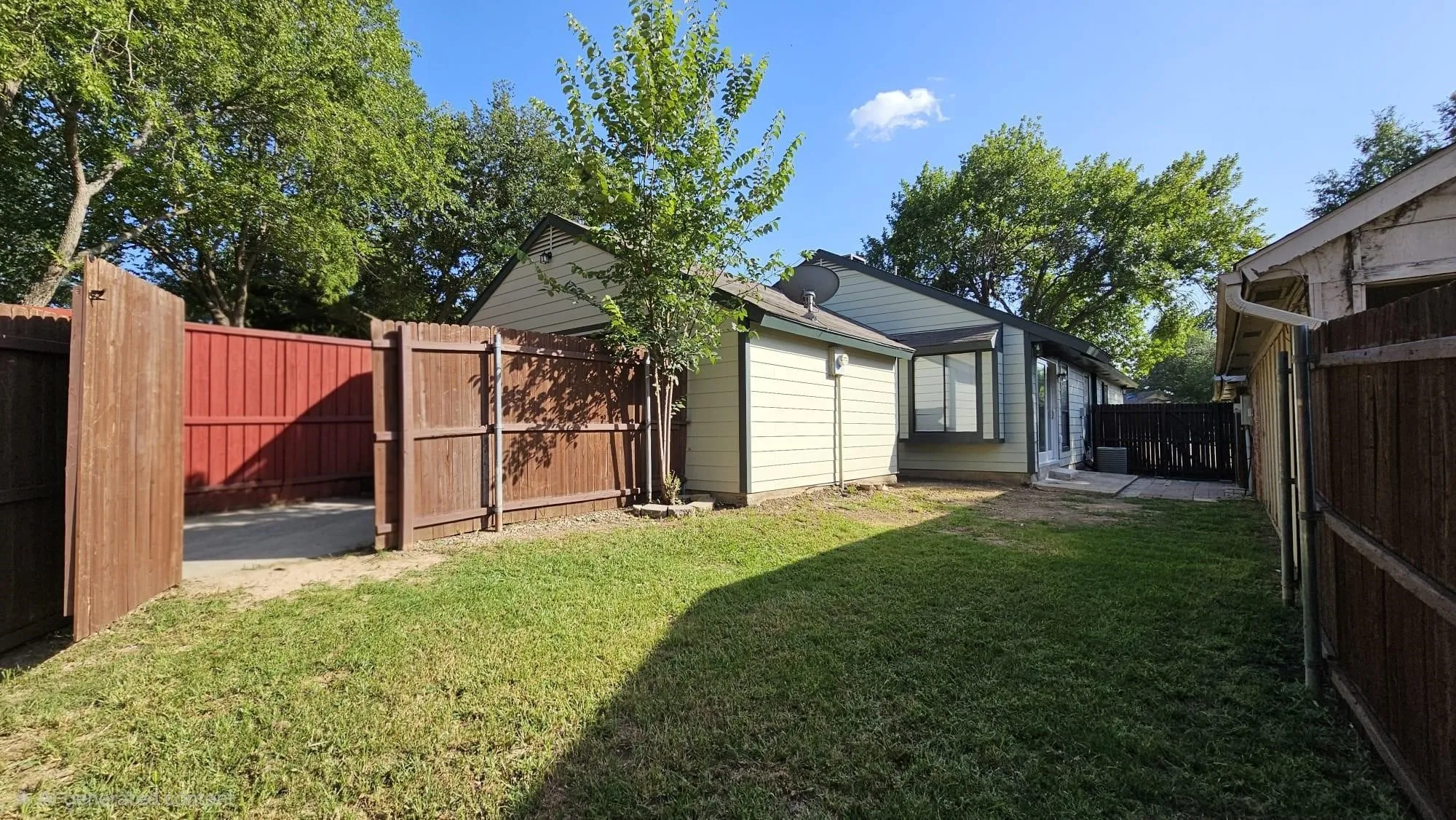 Back Yard Expansive grass lawn with mature trees and wood fencing