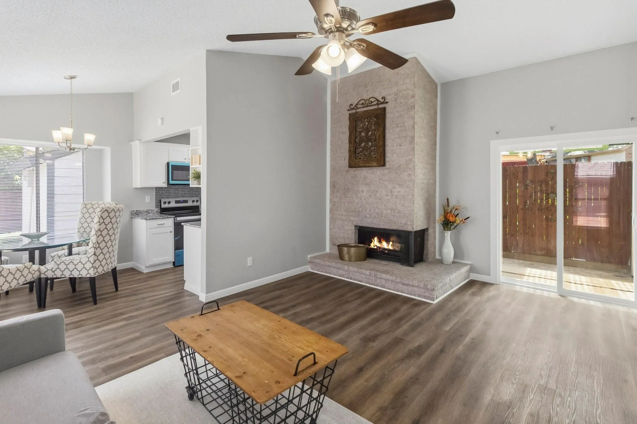 Living area featuring wood-finish flooring, a stone-clad fireplace, and sliding glass doors to the exterior