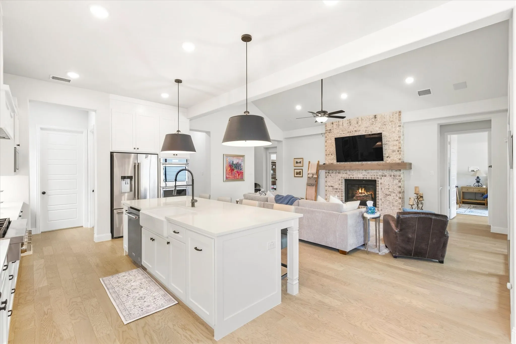 Open Concept , Eat In Kitchen that overlooks the Living Room.  Quartzite Countertops with updated lighting. Door to the right enters into the Master Bedroom.