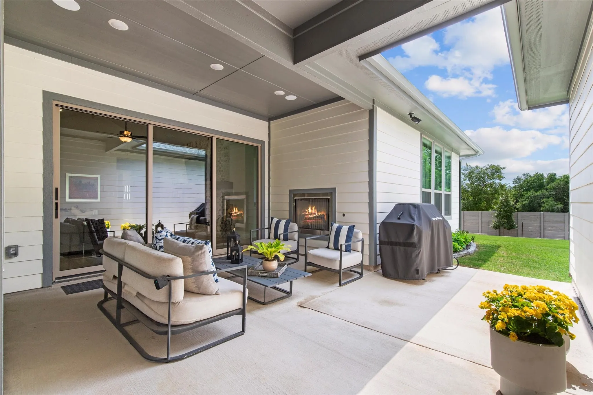 Covered outdoor patio with cozy fireplace and large sliding glass doors that open to the Living room