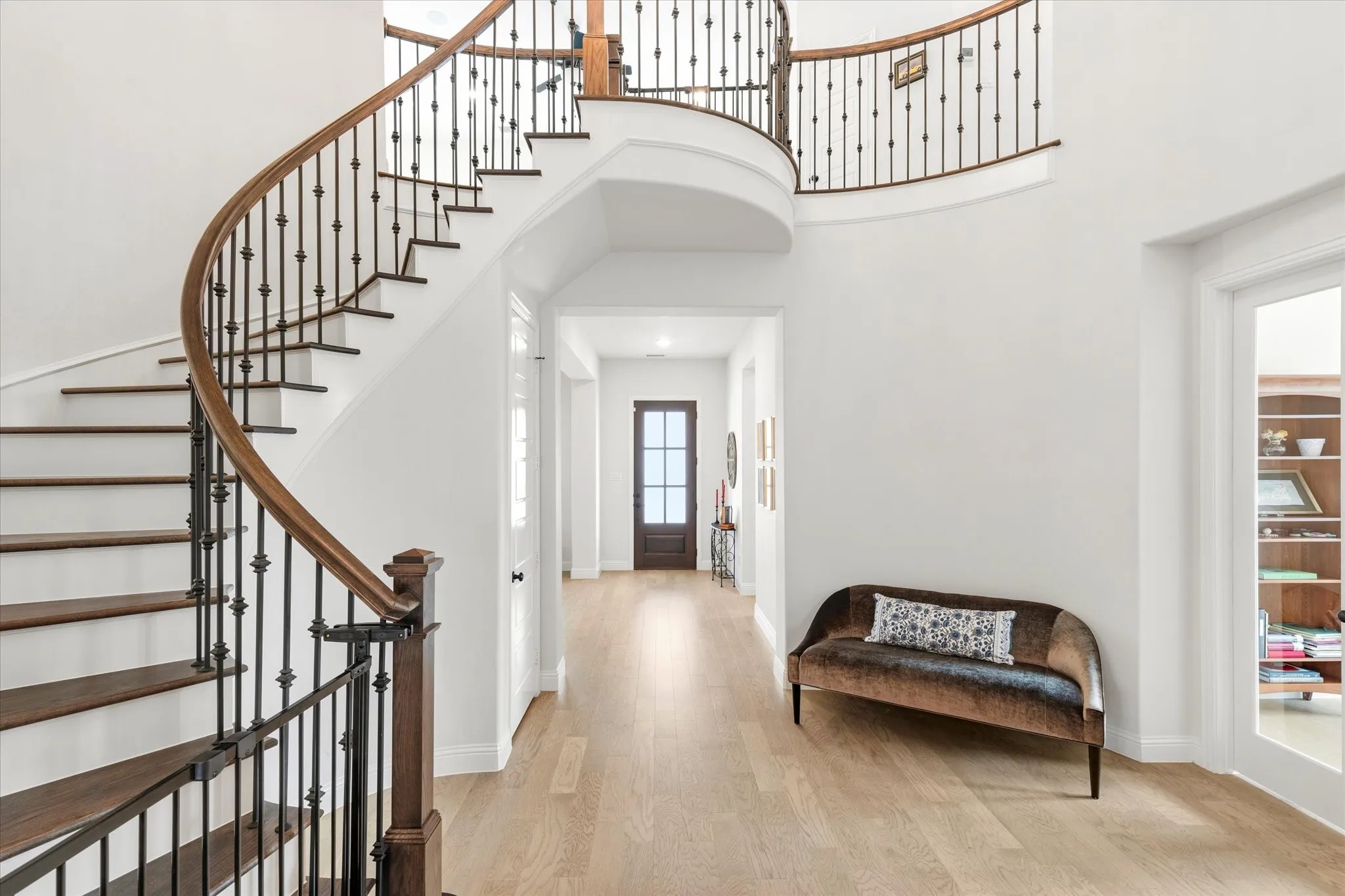 The Door in the back is the front door.  The hallway leads to a central area that has a beautiful curved staircase leading to the Game Room and upstairs bedrooms.  The office is to the right.