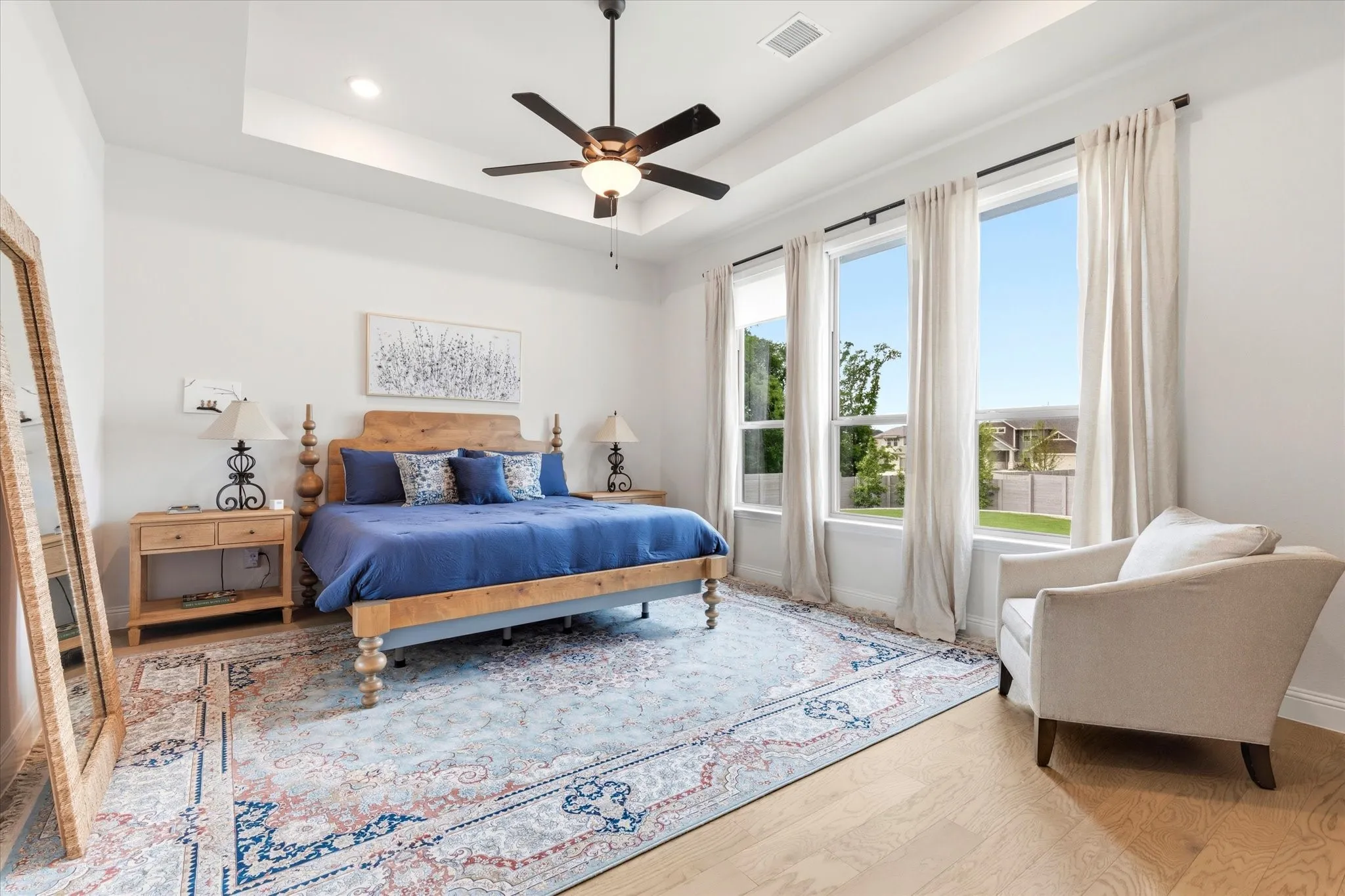Primary Bedroom is directly from the Main Living Room.  Large windows overlook the beautiful backyard and lets in lots of natural light. Nice Tray ceiling make this space feel even larger.