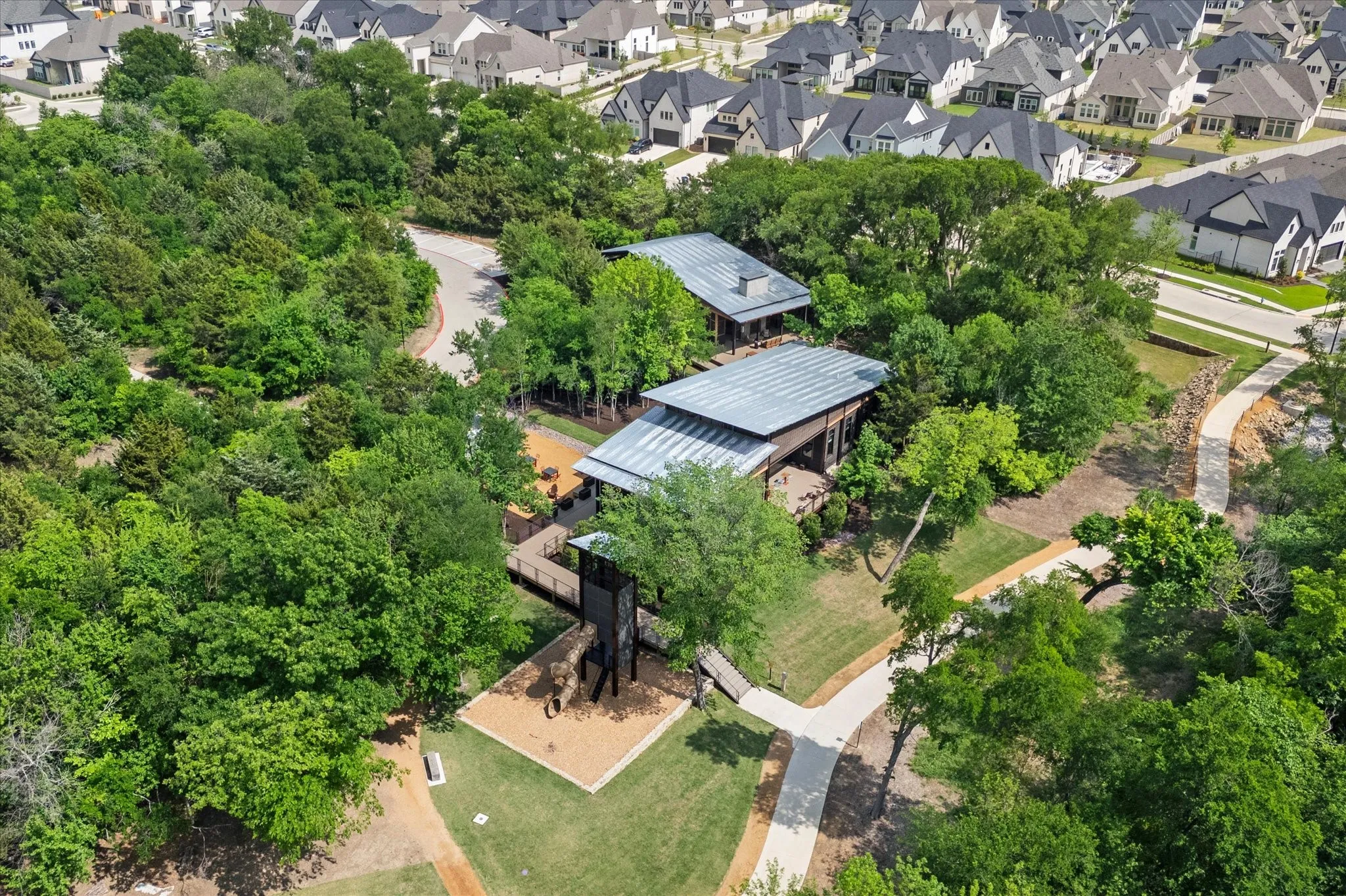 Expansive green spaces featuring mature trees and paved pathways with a food truck court.