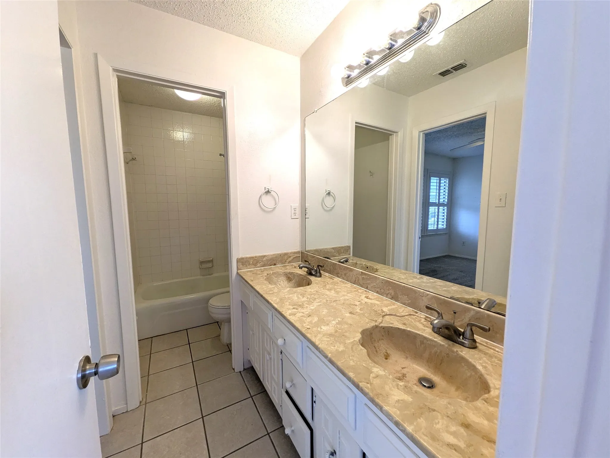 Bathroom featuring a double vanity with stone countertops and integrated sinks