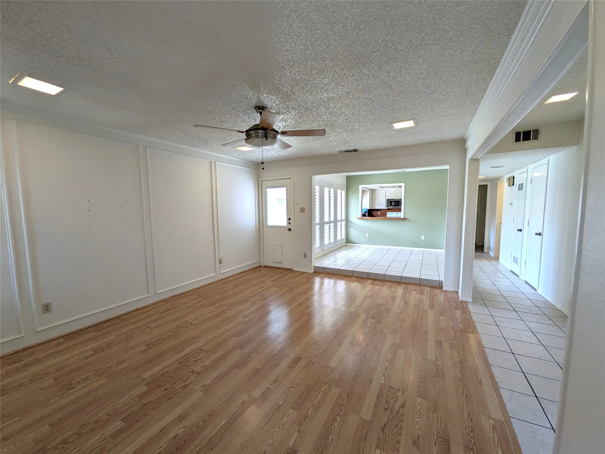 Living area featuring wood-finish flooring and decorative wall molding
