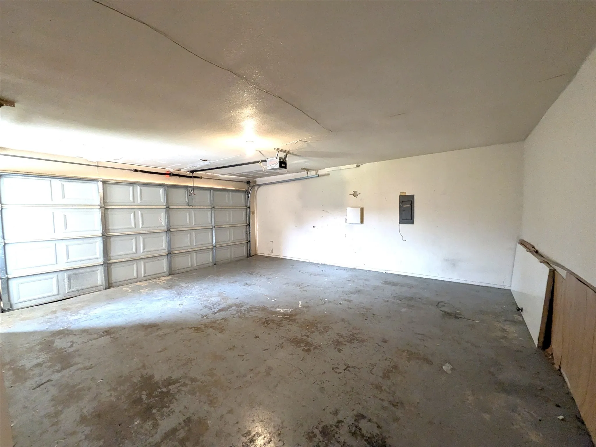 Spacious garage featuring a concrete floor, painted walls, and a large sectional garage door