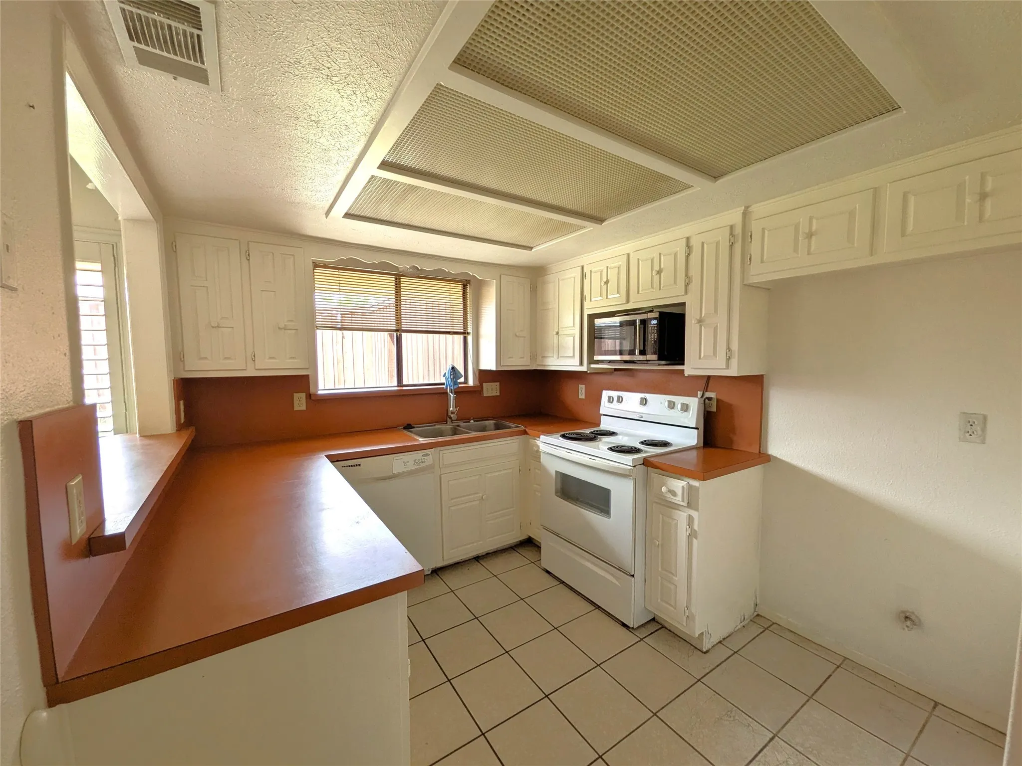 Kitchen featuring white cabinetry, brown countertops, and white tile​​‌​​​​‌​​‌‌​‌‌​​​‌‌​‌​‌​‌​​​‌​​ flooring