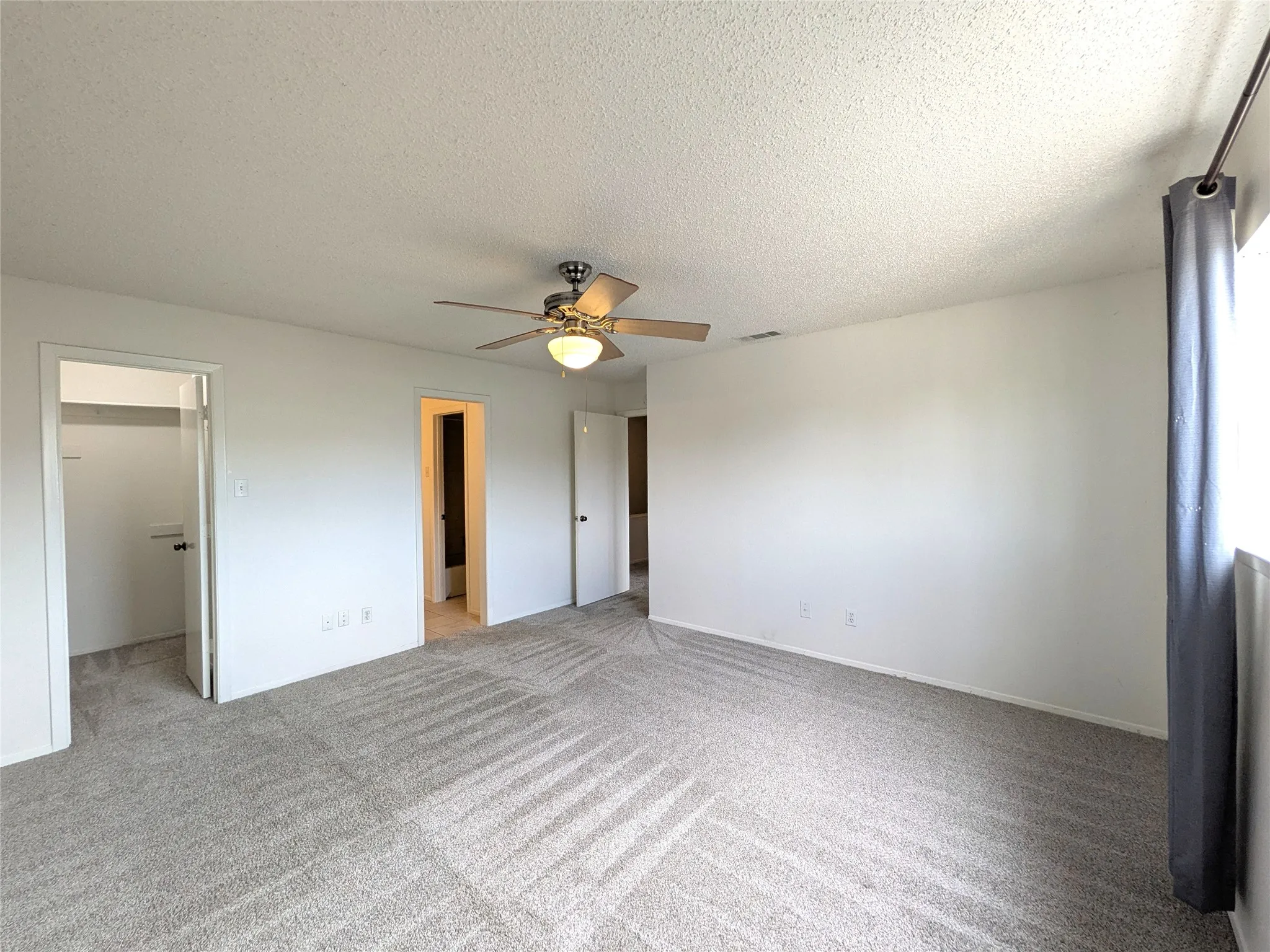 Spacious interior room featuring light gray carpet flooring