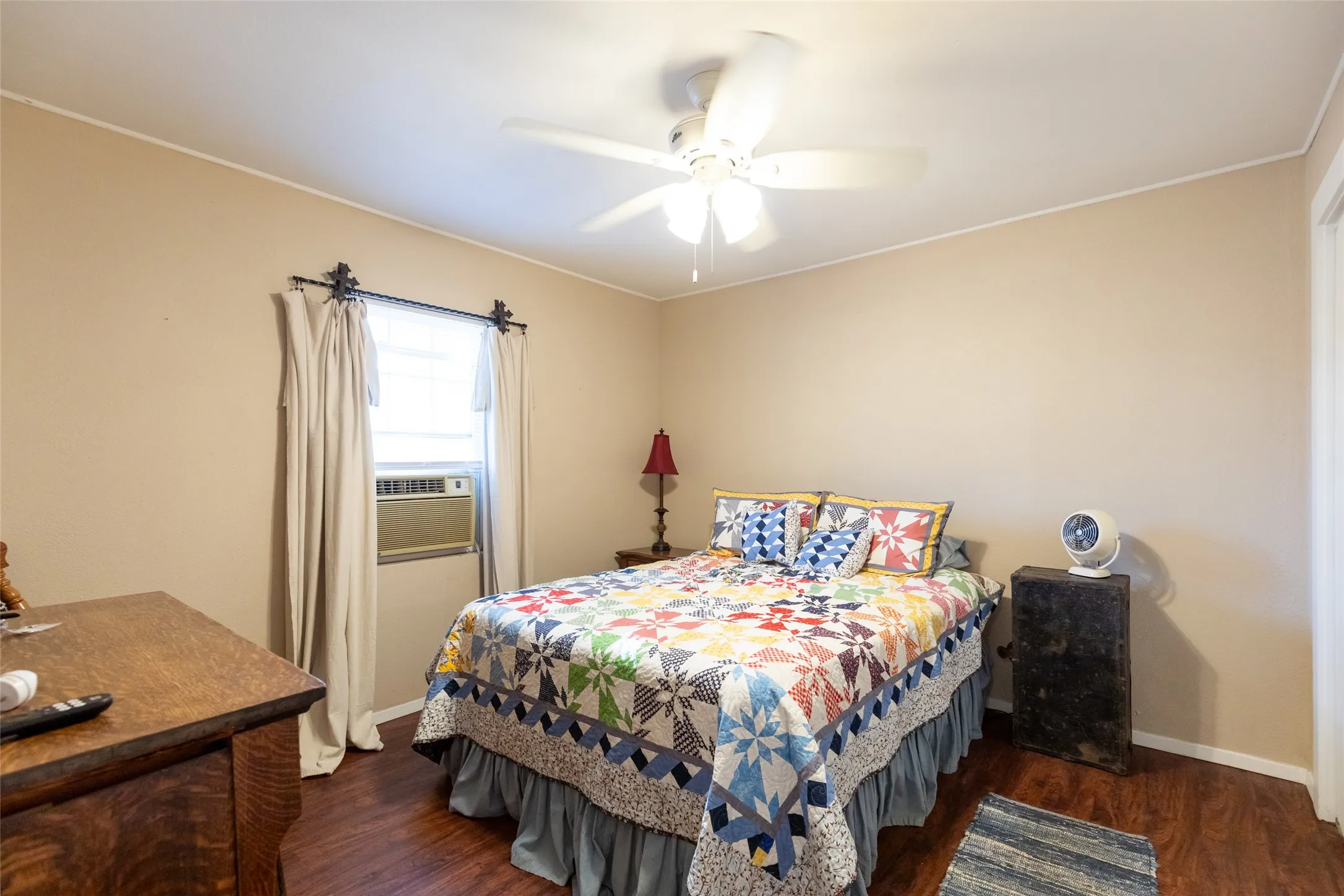 Wood-finish flooring, ceiling fan, and window-mounted air conditioning unit
