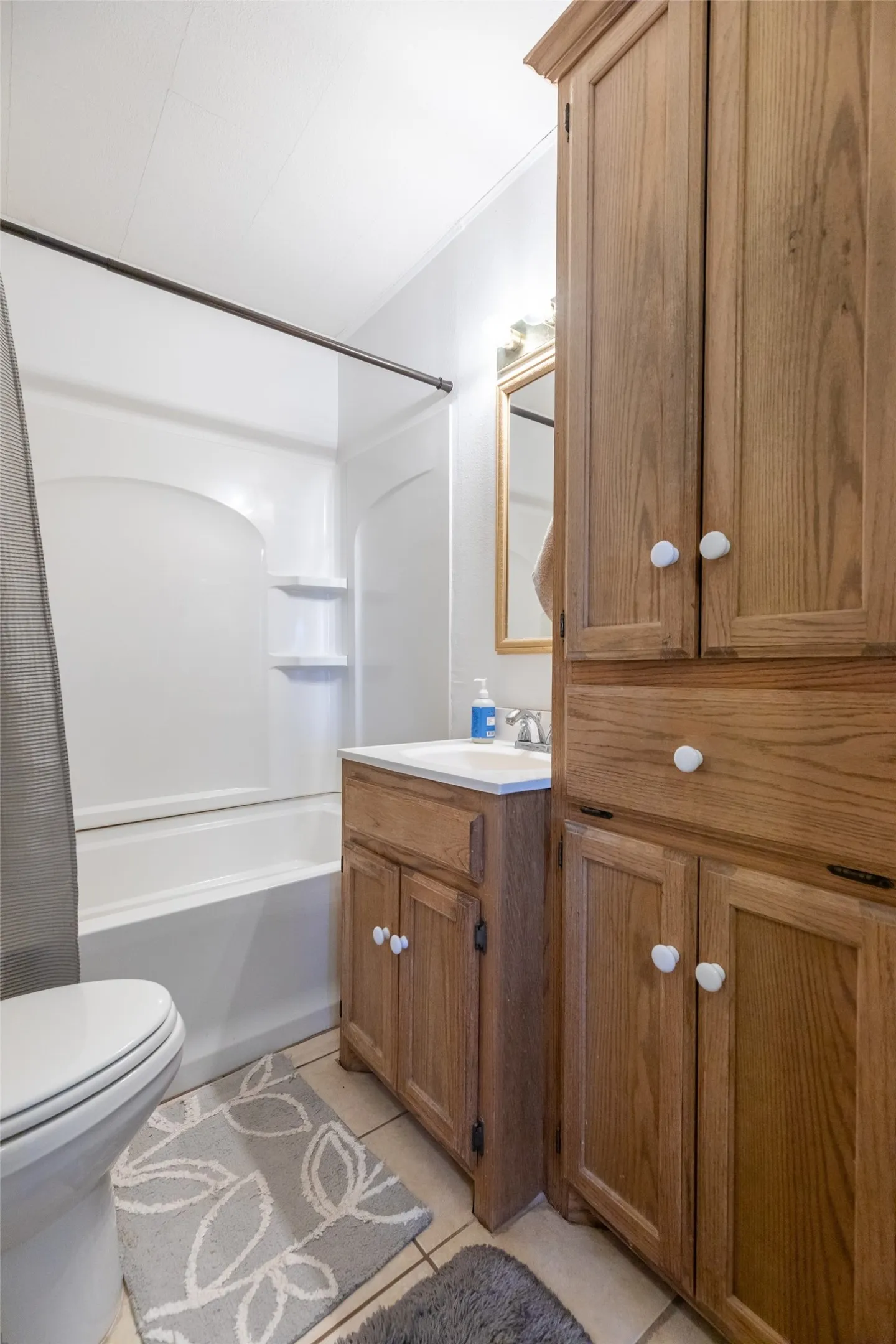 White bathtub and shower combination with integrated shelving
