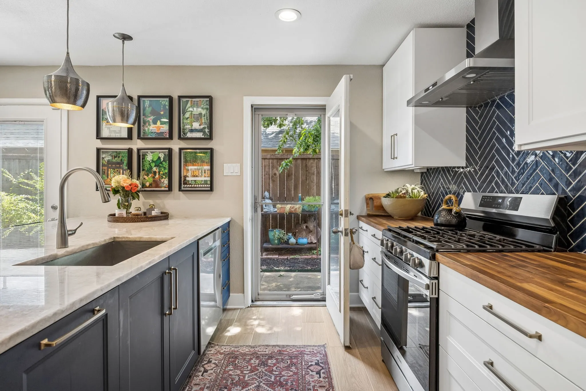 Kitchen featuring two-tone cabinetry, quartzite countertops, a herringbone tile backsplash, wood countertops, and stainless steel appliances