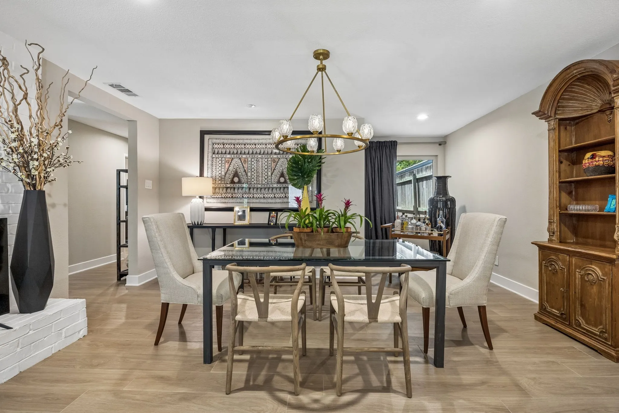 Dining area featuring tile  flooring, a contemporary chandelier, recessed lighting, and a white brick fireplace surround