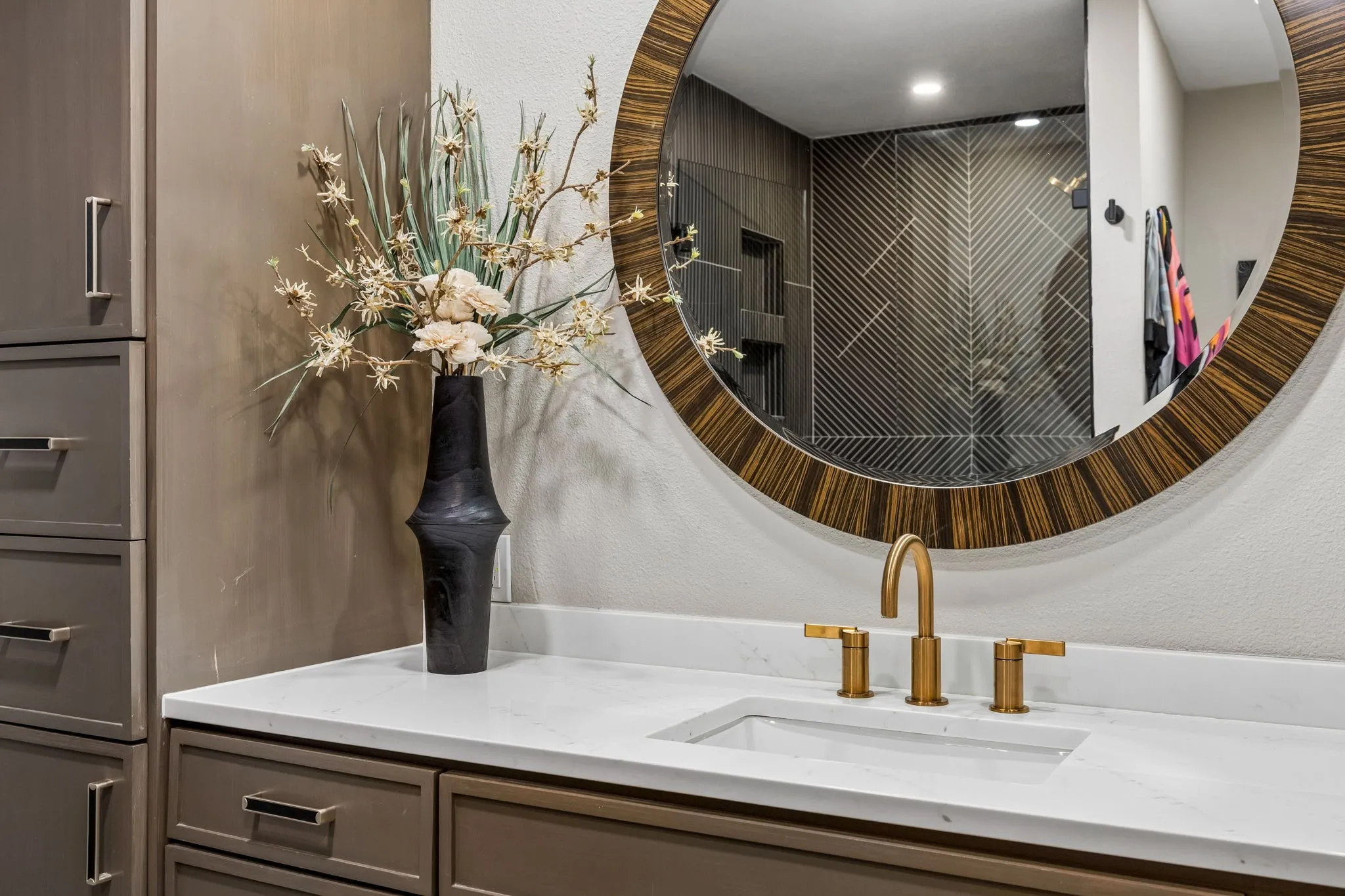 White quartz countertop with an undermount sink and a brass-finish faucet