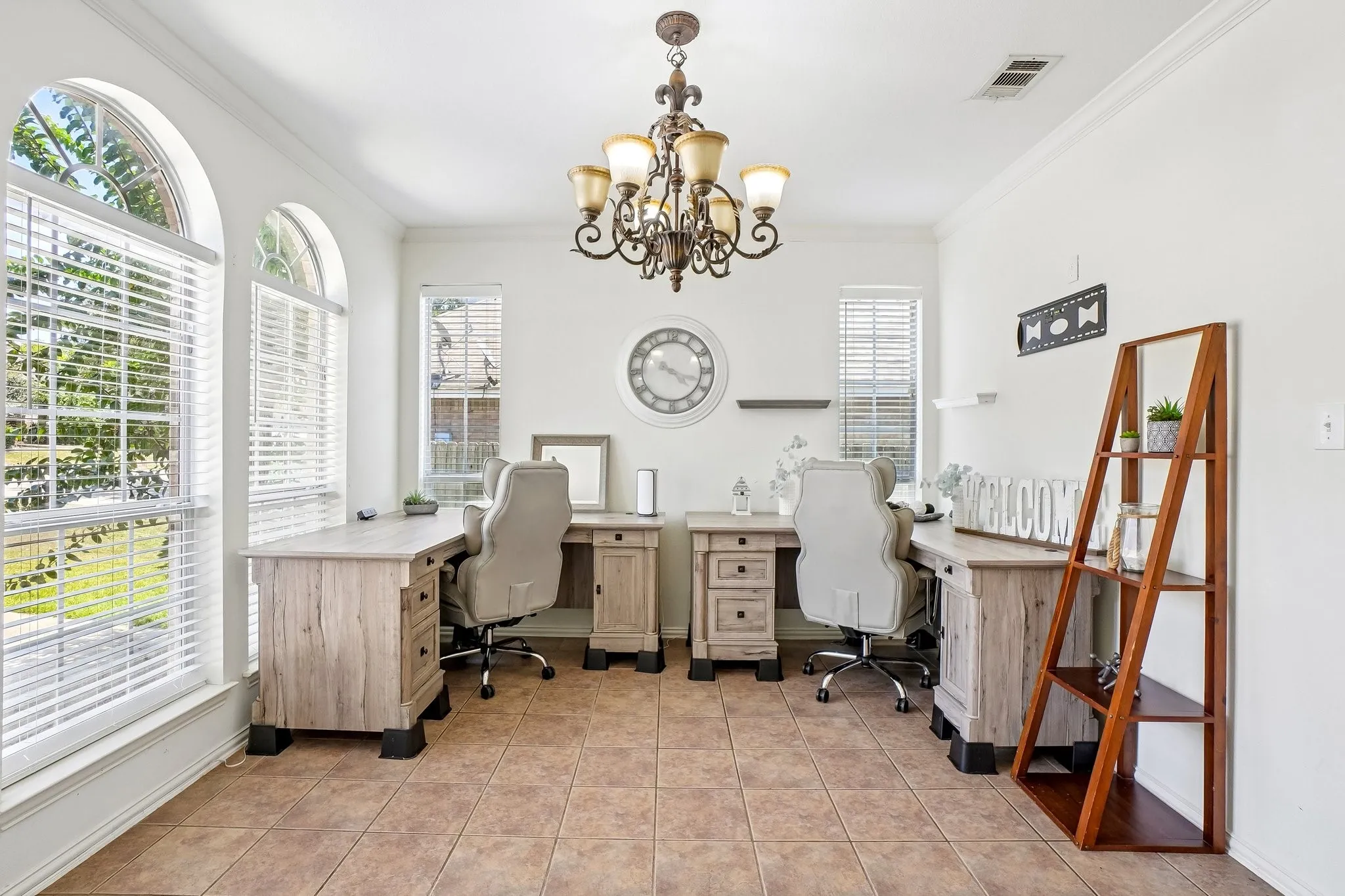 Room featuring light-toned tile flooring, white walls, and a decorative chandelier
