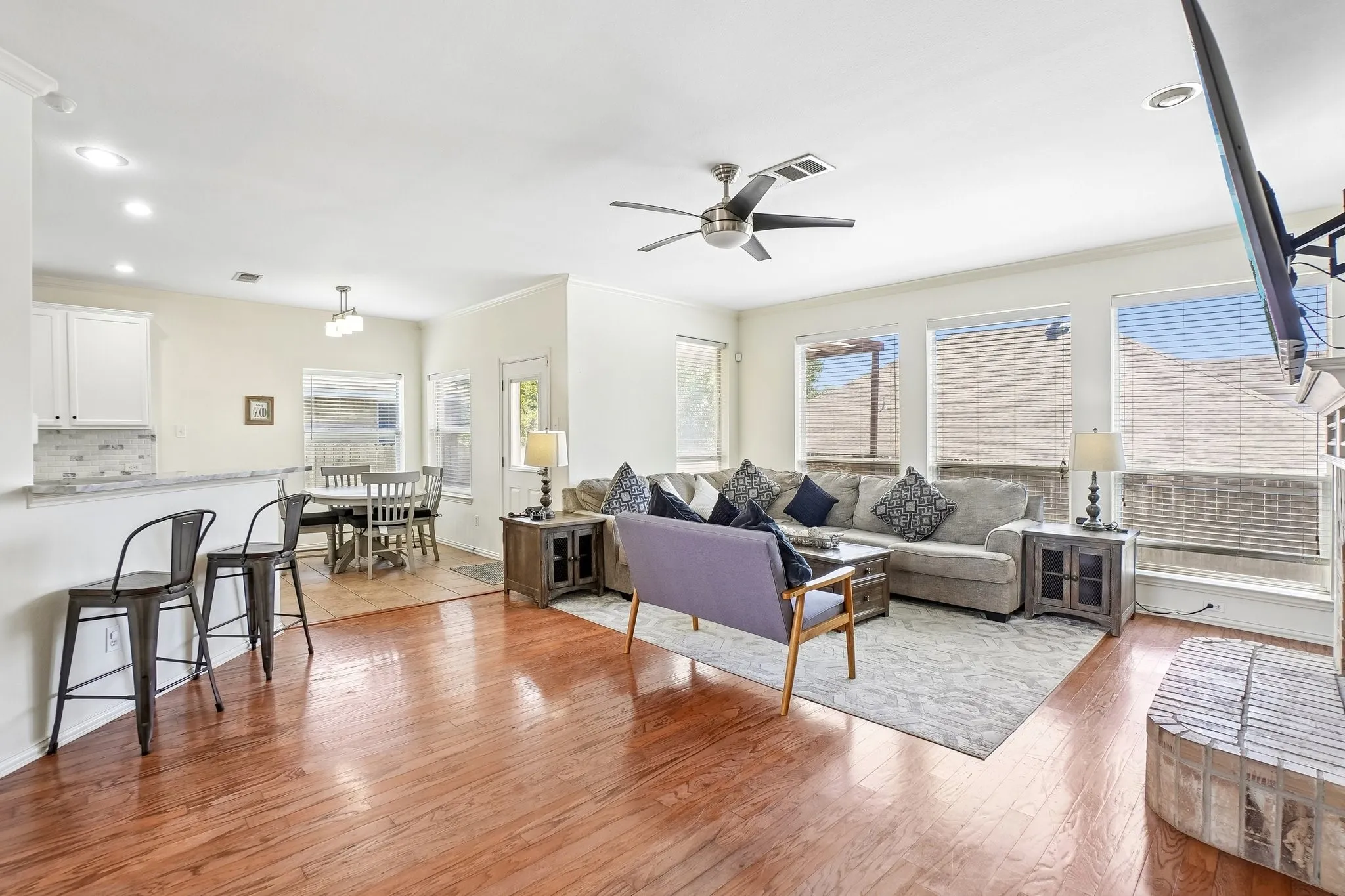 Expansive living area featuring wood-finish flooring and a ceiling fan