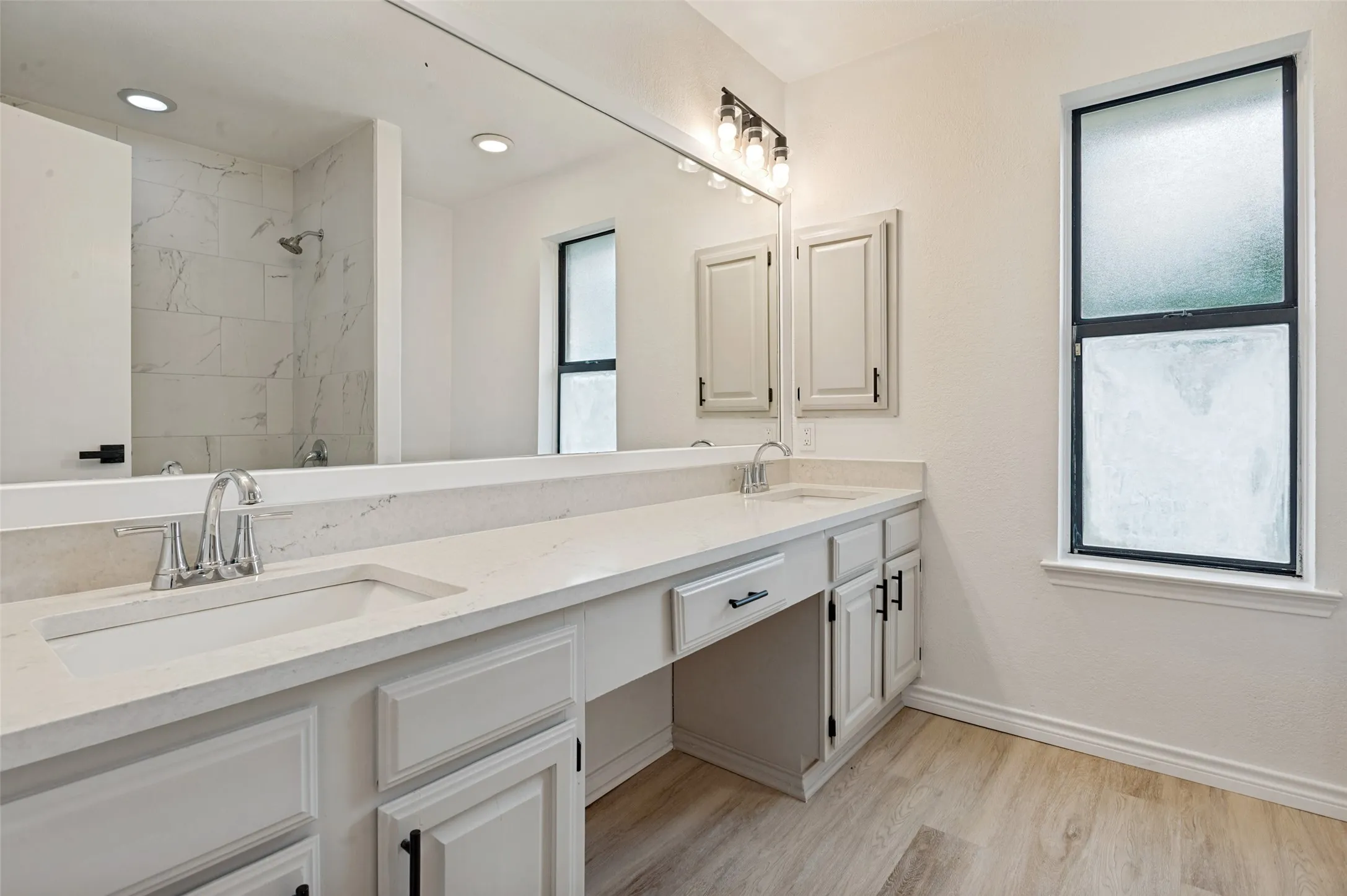Dual vanity with undermount sinks, an extensive countertop, and light-toned cabinetry