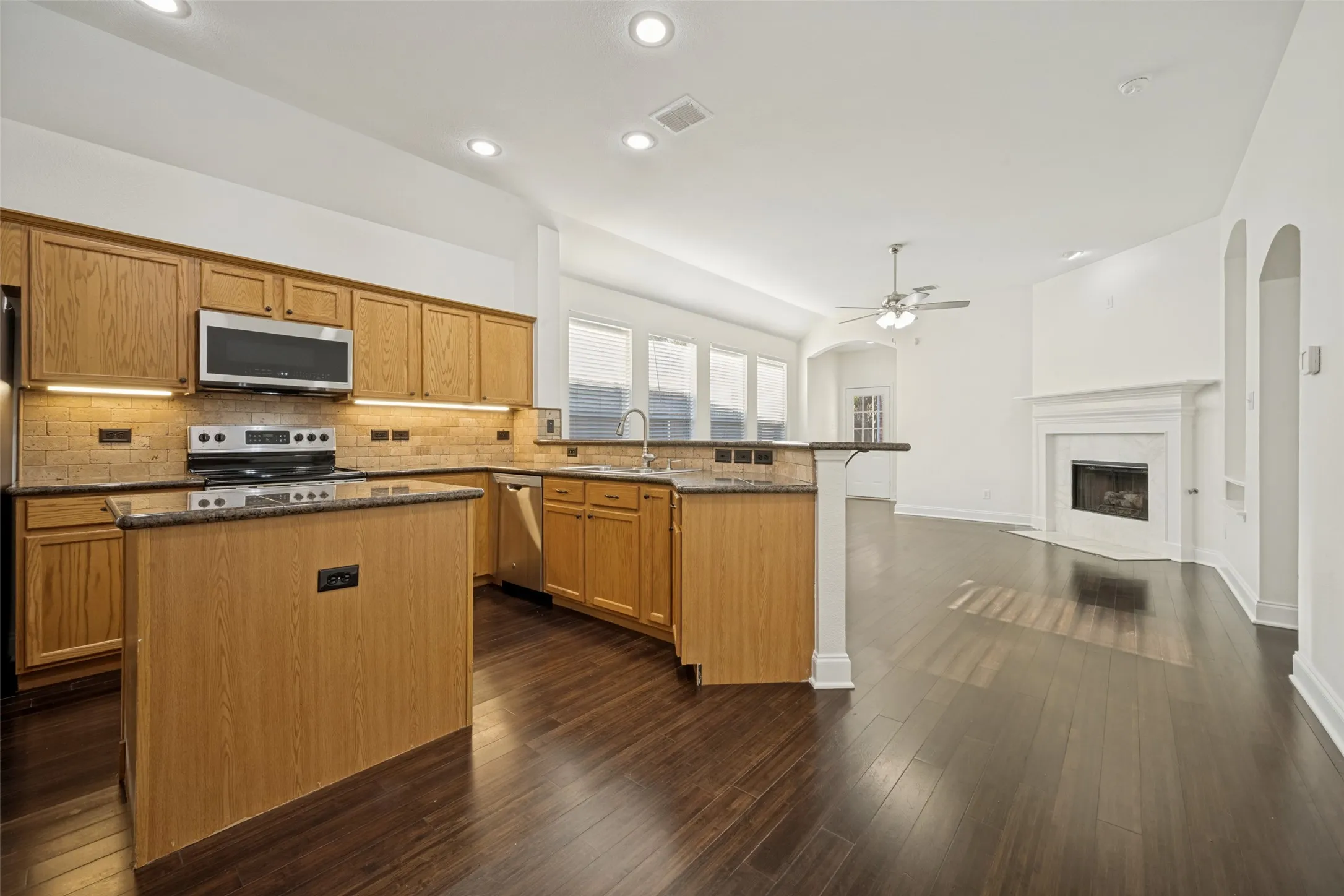 Kitchen featuring wood cabinetry, stainless steel appliances, and a central island