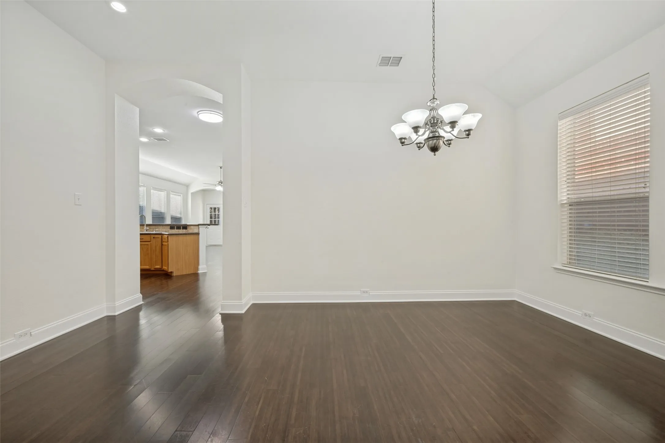 Dark wood-finish flooring with white baseboards throughout