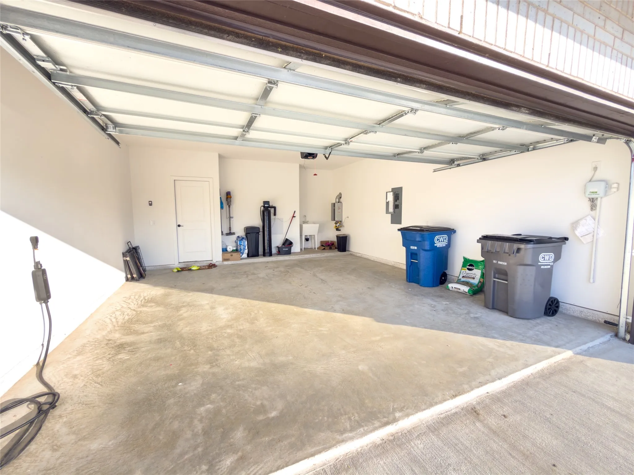 Garage with electric panel and a sink