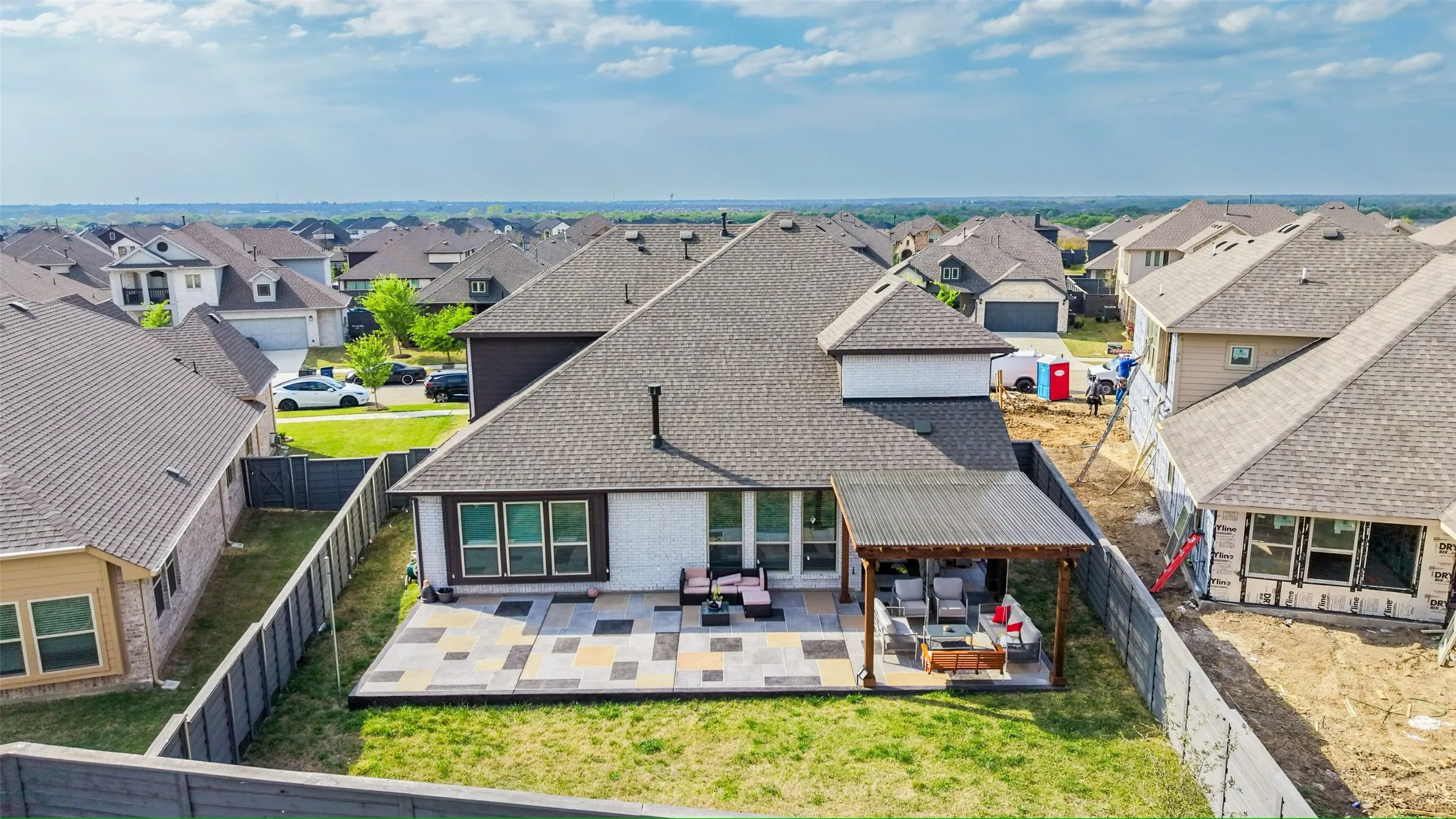 Rear view of property featuring a patio, a fenced backyard, a residential view, and a shingled roof