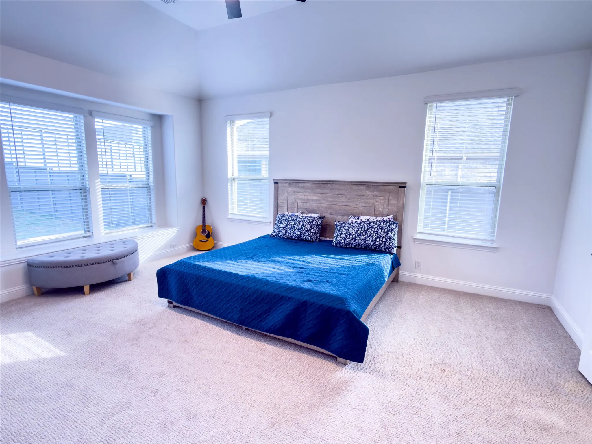 Carpeted bedroom with ceiling fan and lofted ceiling