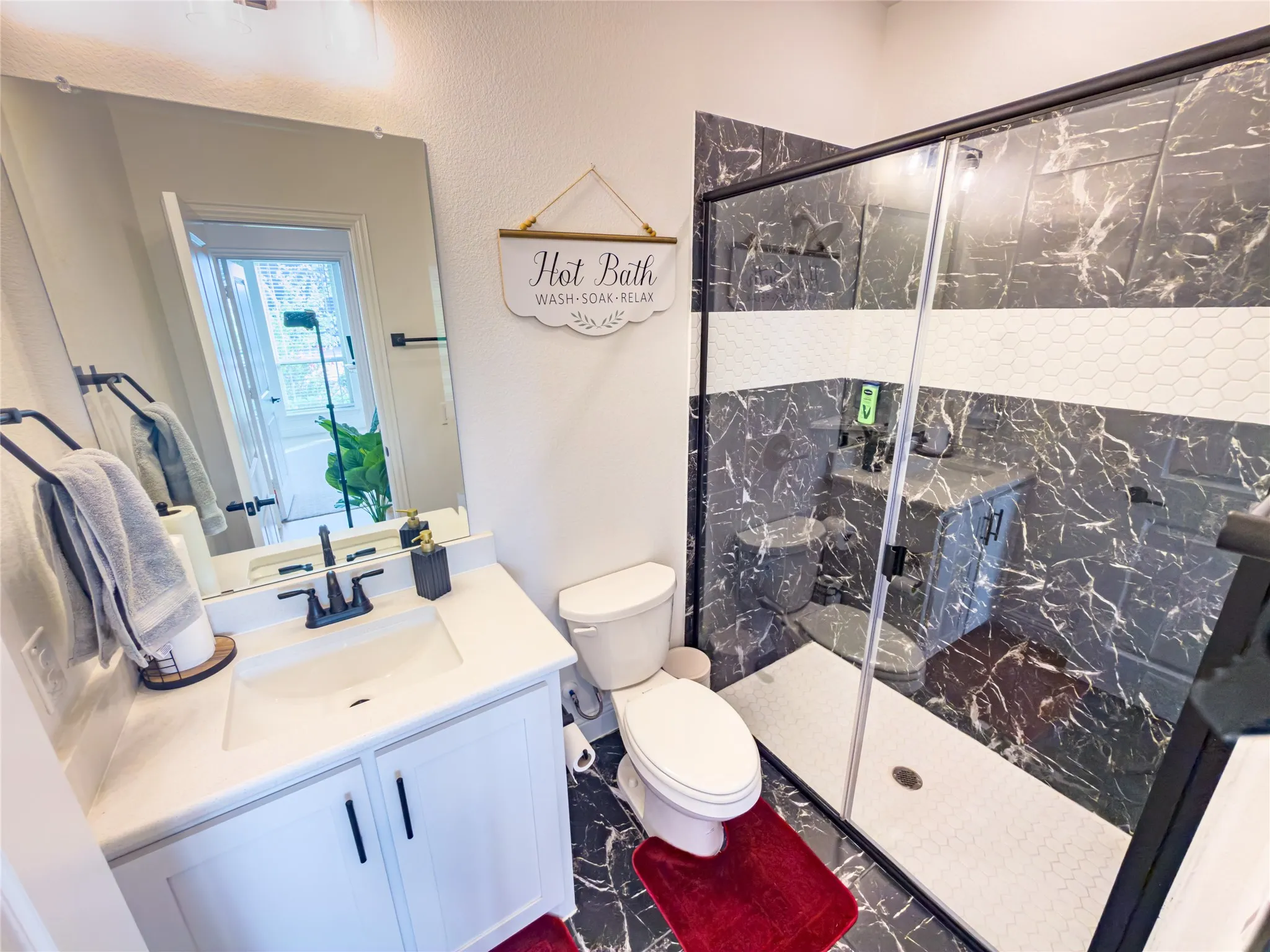 Full bath with vanity and a marble finish shower
