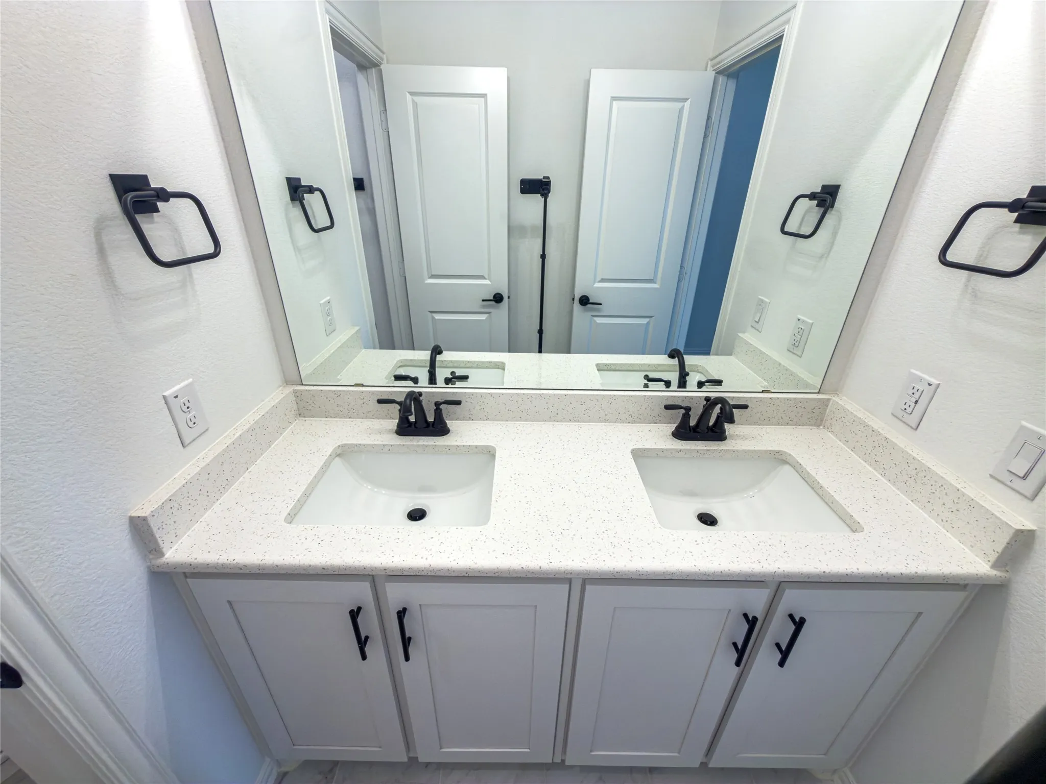 Bathroom with double vanity and a textured wall
