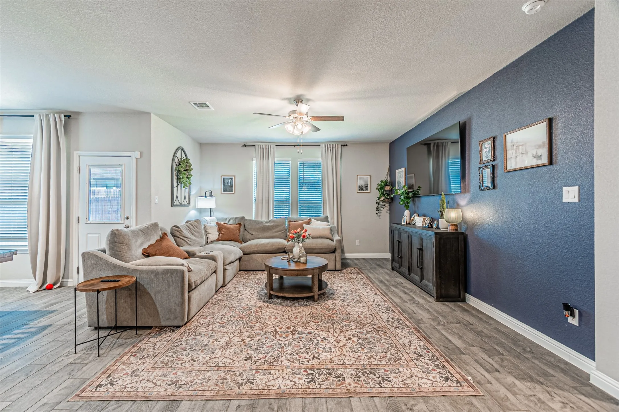 Recessed lighting, wood-finish flooring, ceiling fan, and multiple windows with blinds