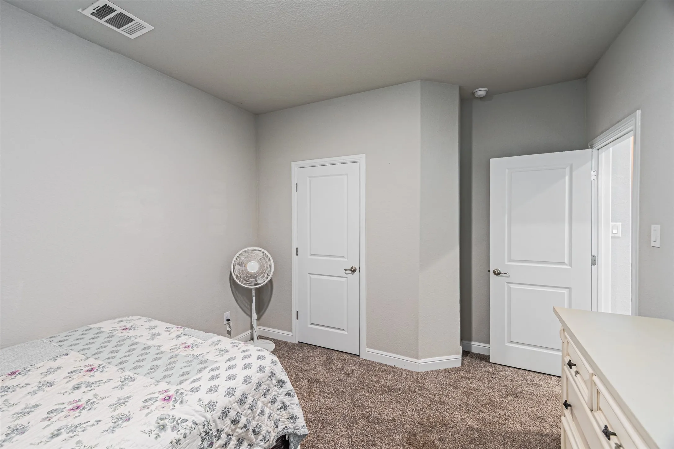 Neutral paint tones, textured walls, white trim, and carpeted flooring