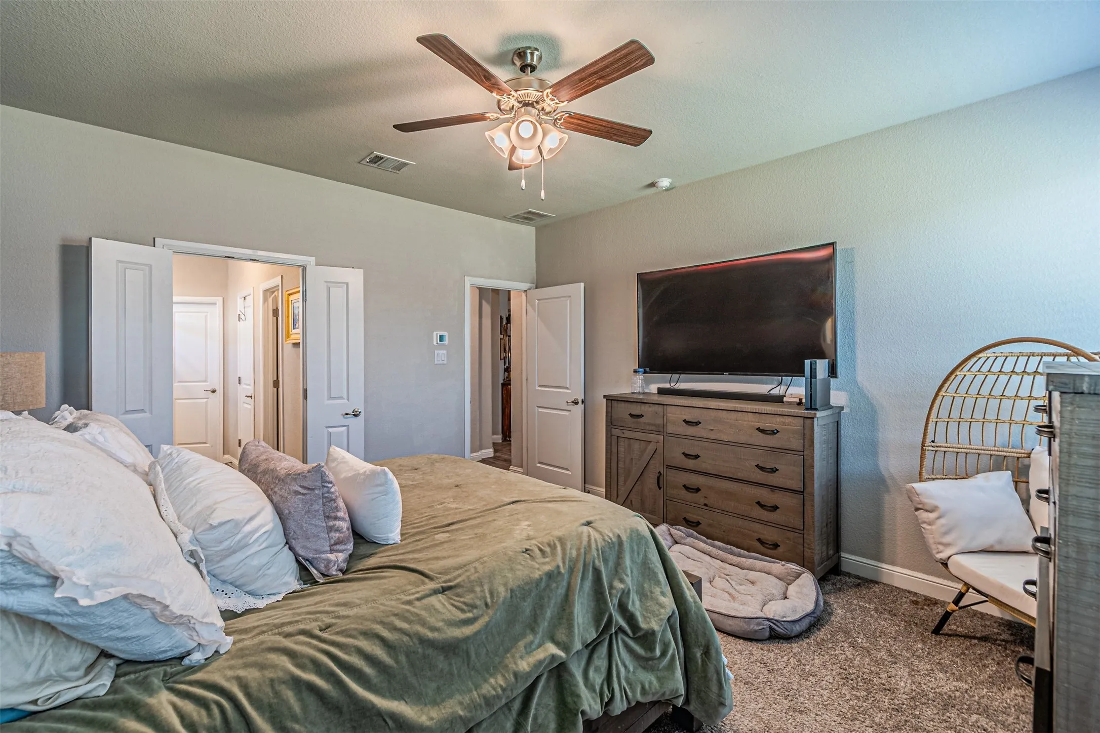 Textured carpeting, neutral wall paint, and a ceiling fan with integrated lighting