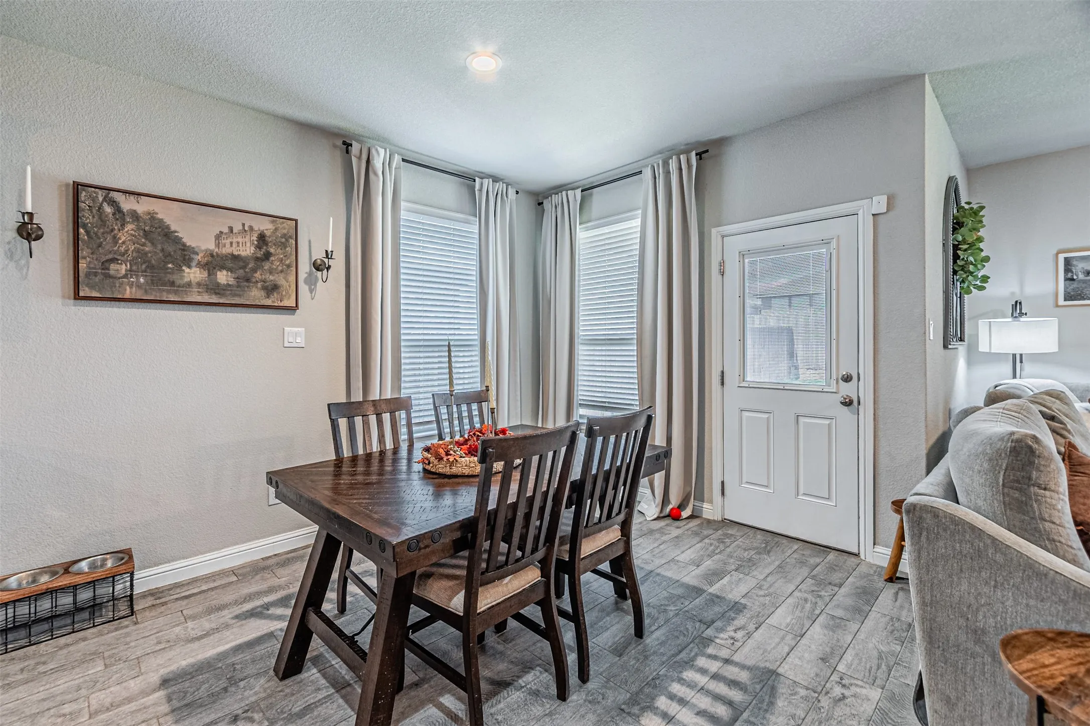 Recessed ceiling lighting, durable wood-finish flooring, and a paneled exterior door with an inset privacy glass panel