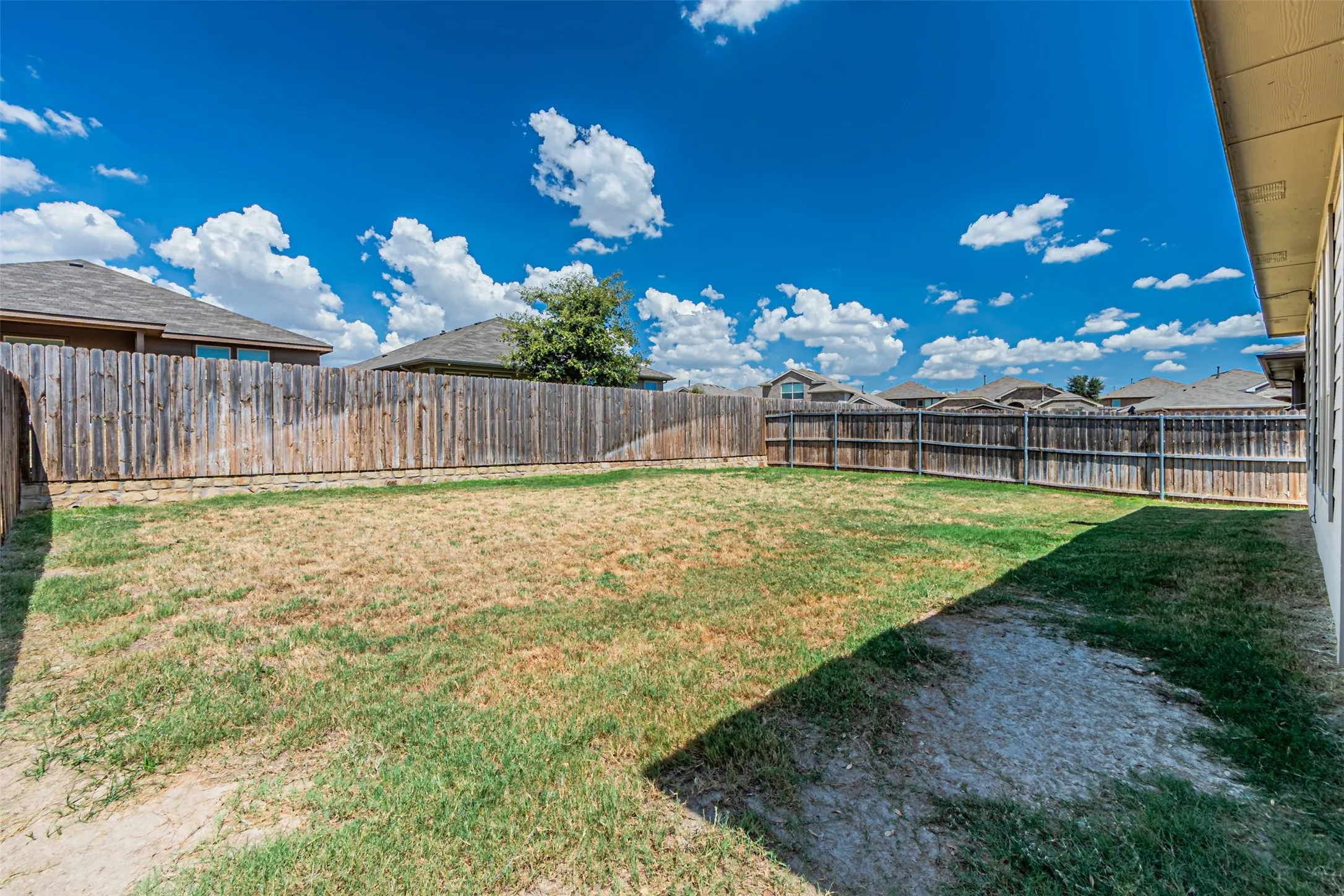 Expansive backyard space enclosed by a perimeter privacy fence